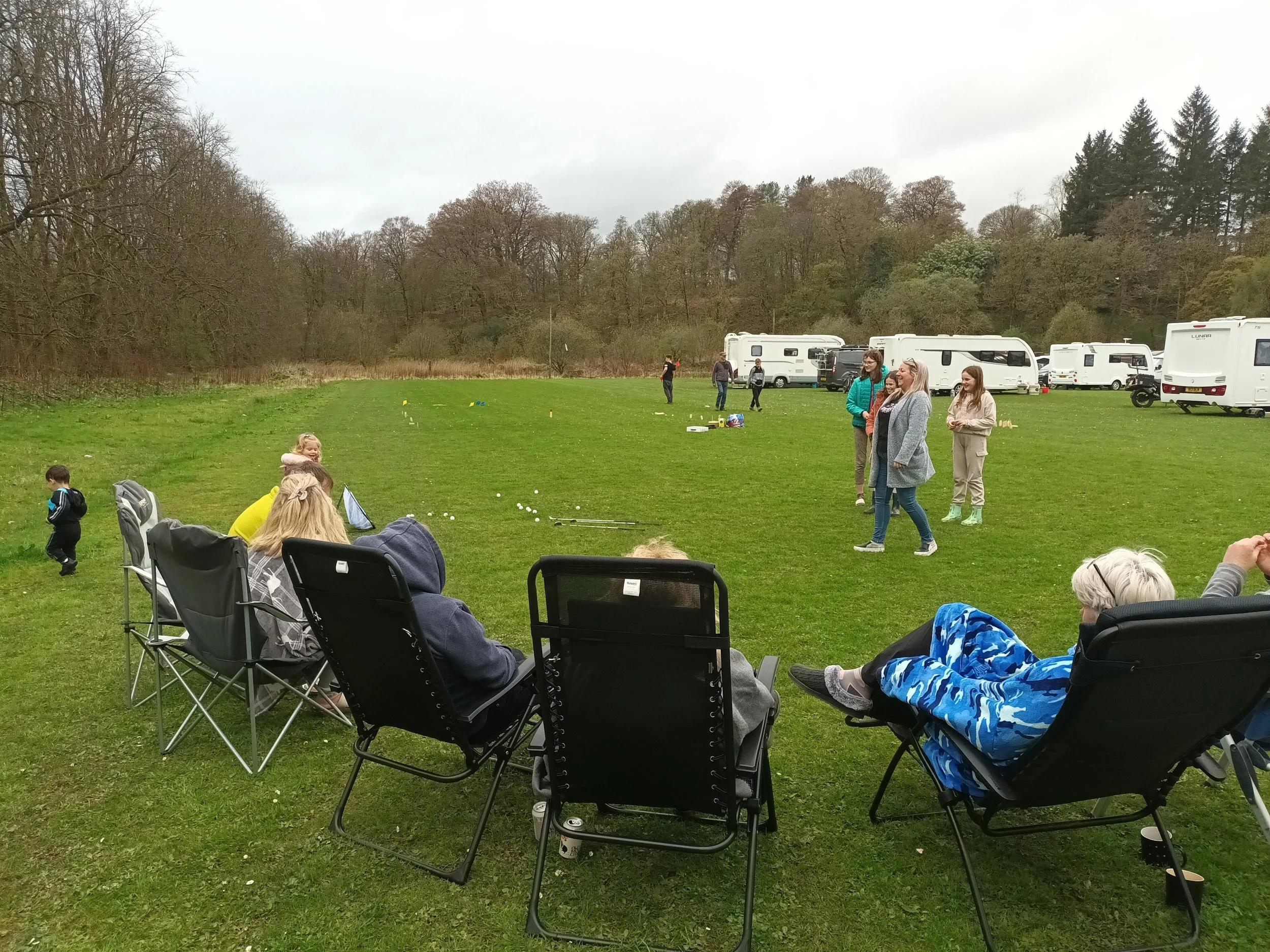 people sitting watching games in caravan site
