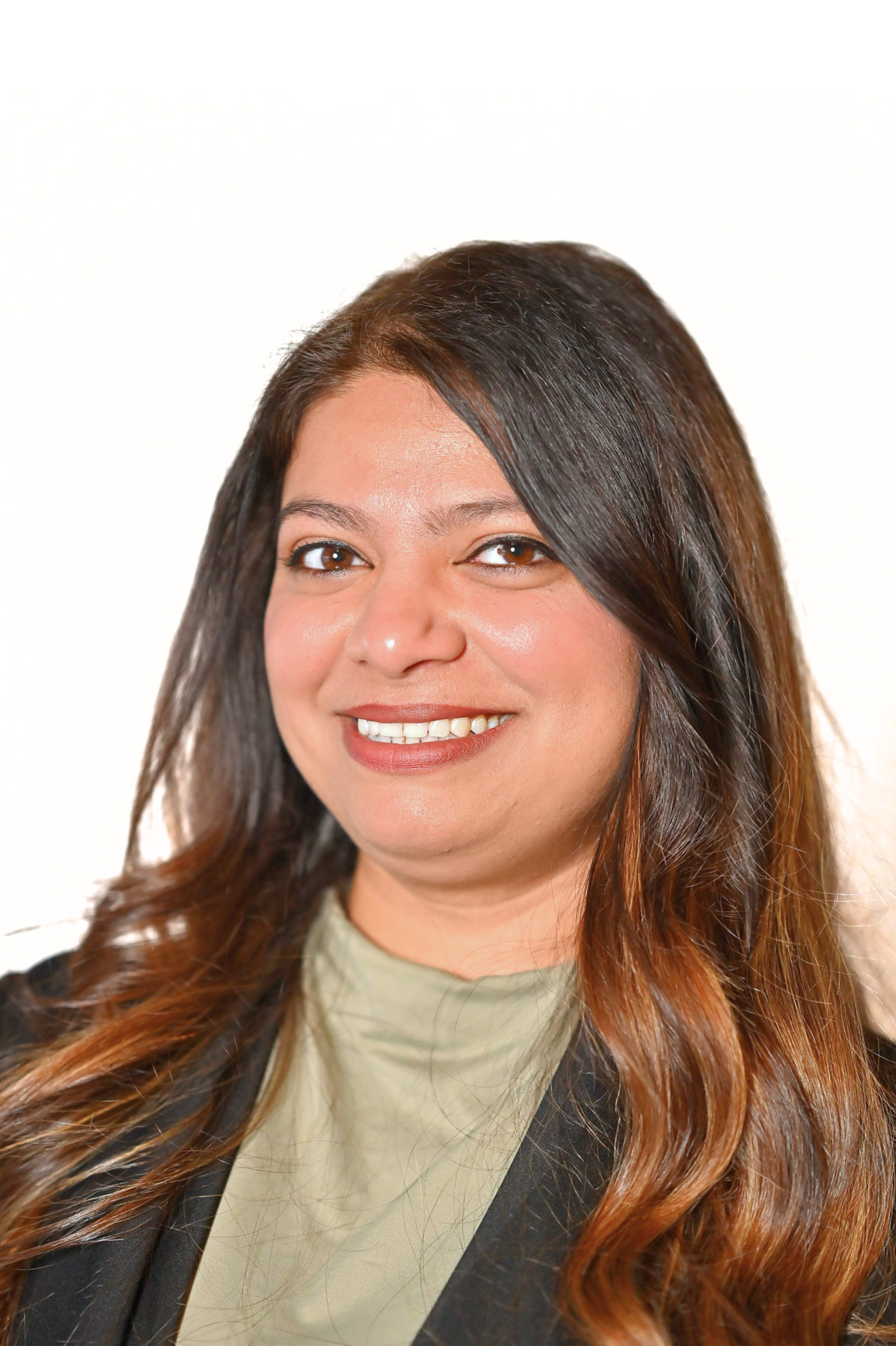 Smiling woman with long, wavy hair wearing a black blazer.