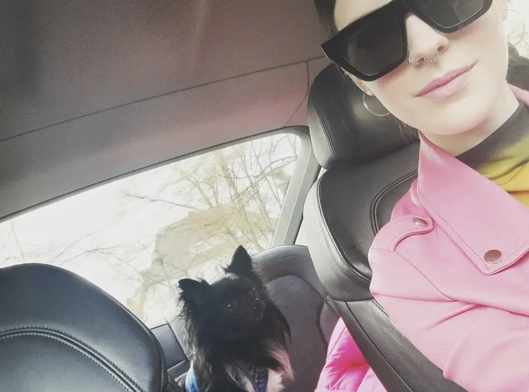 Frau mit Sonnenbrille im Auto mit kleinem Hund – Alltag, Freiheit und ein erfülltes kinderfreies Leben.