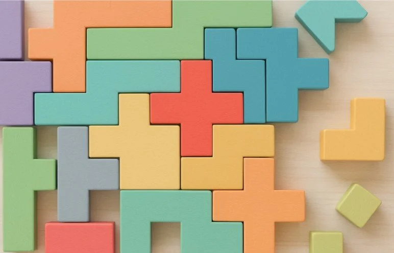 Colorful blocks fitting together like a puzzle, resembling Tetris pieces.