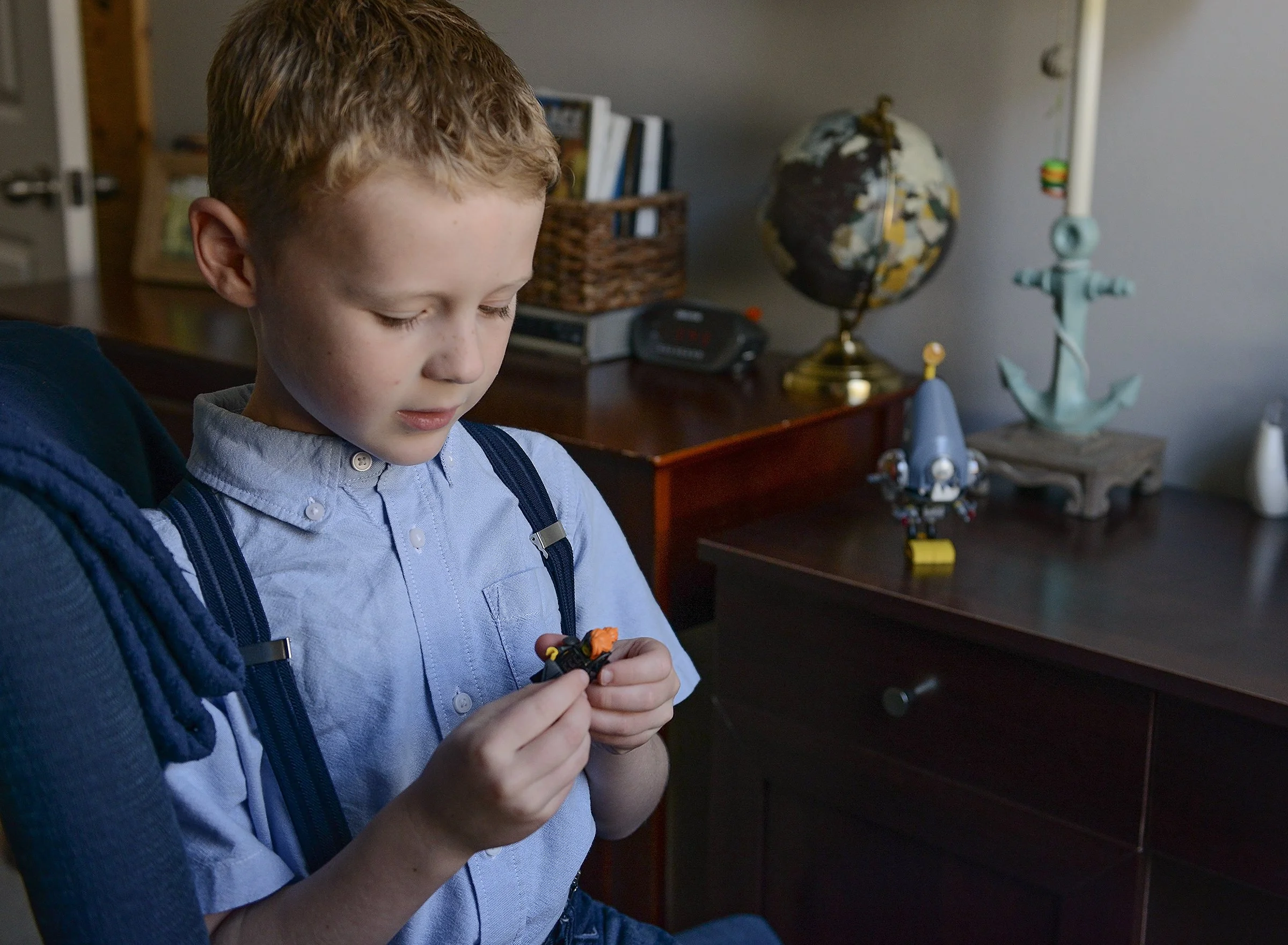 Young boy playing with legos in his bedroom at home