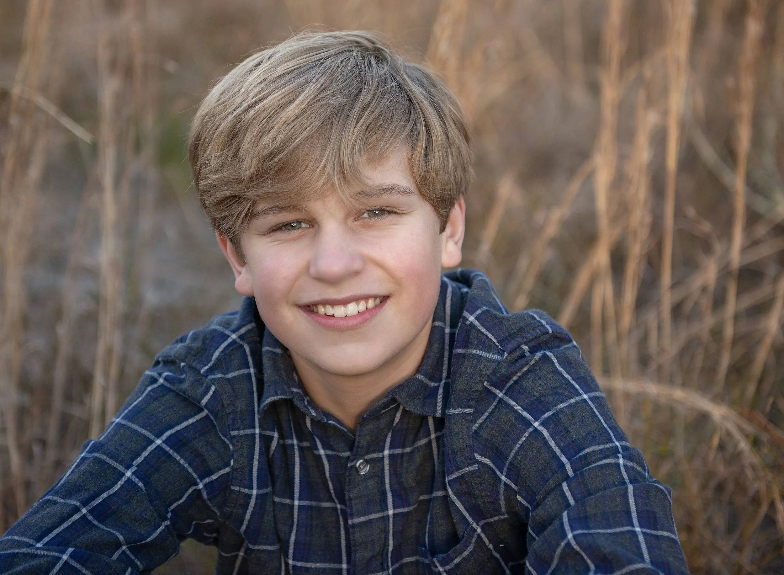 Smiling teenage boy sitting in a field 