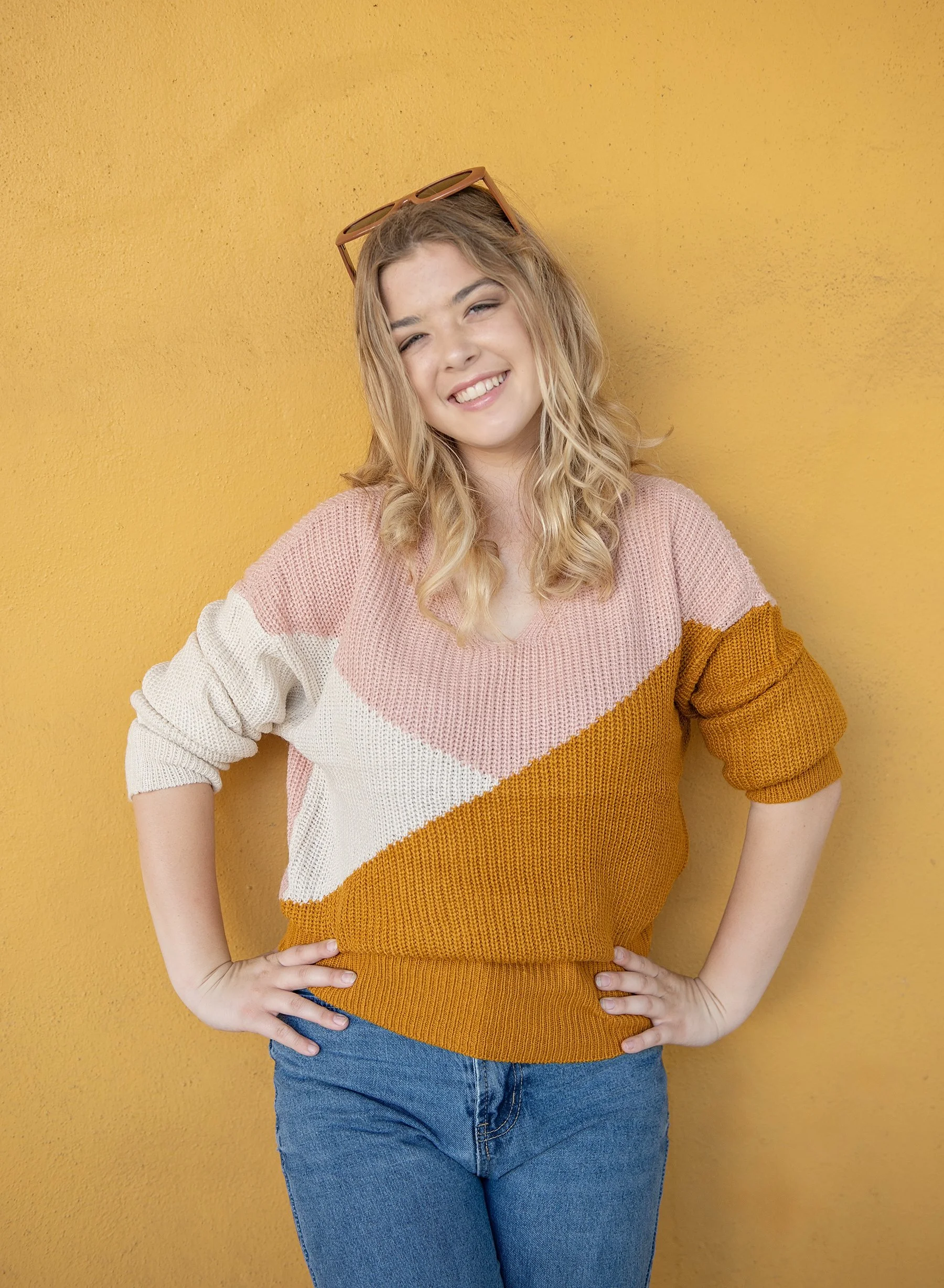 Teen girl leaning against a yellow wall