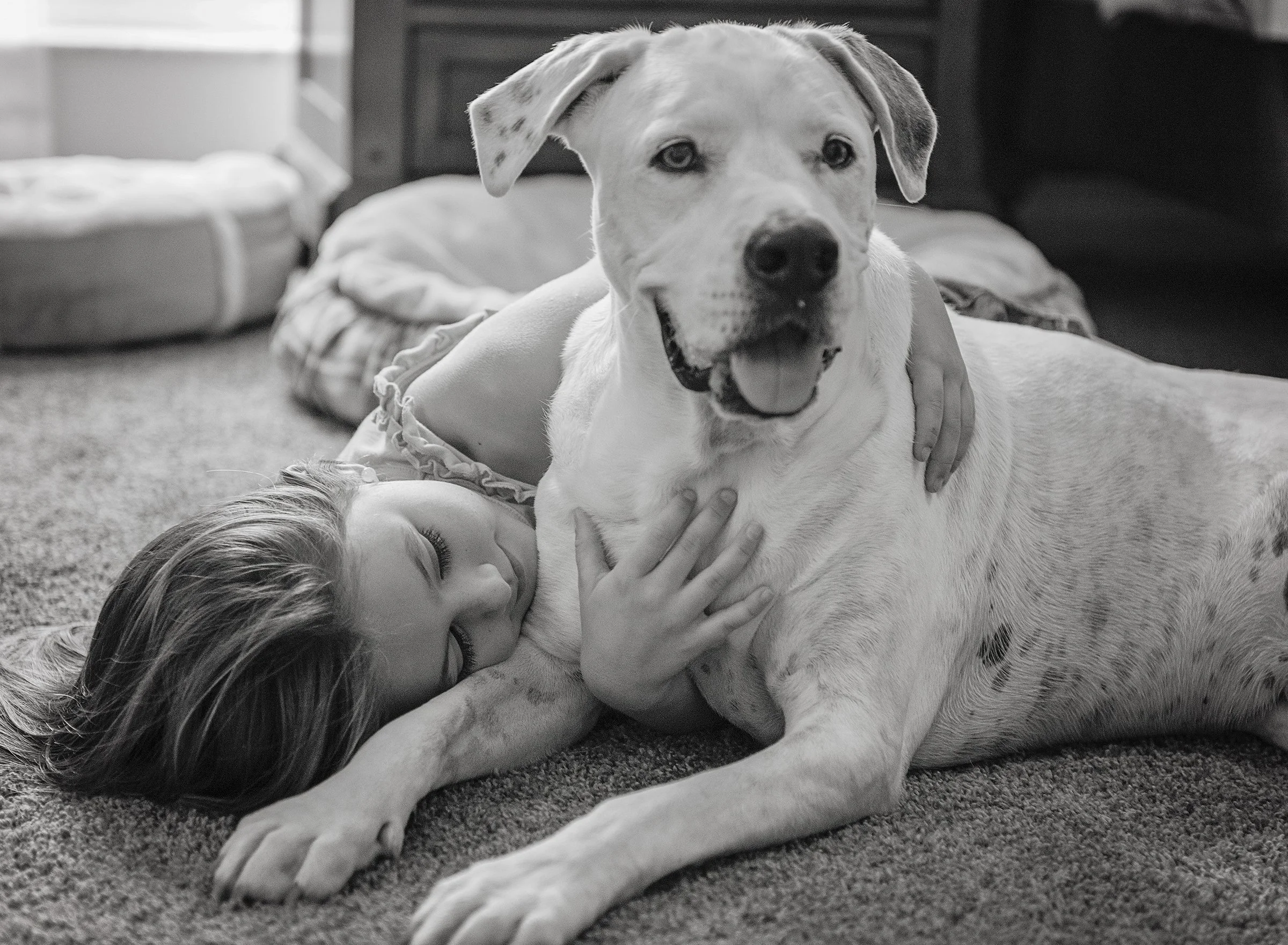 Young girl laying on the ground with her dog