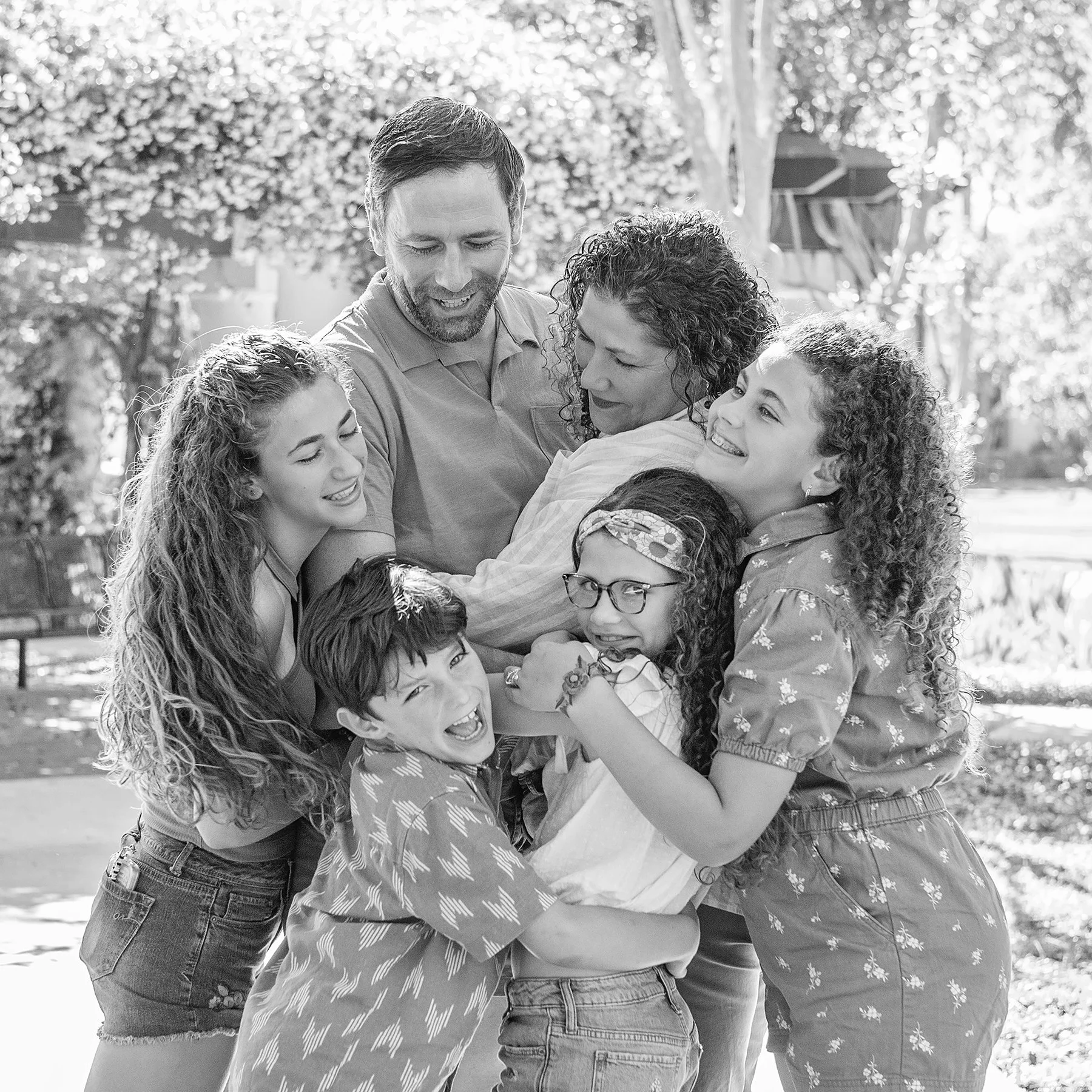 Family of six hugging and laughing