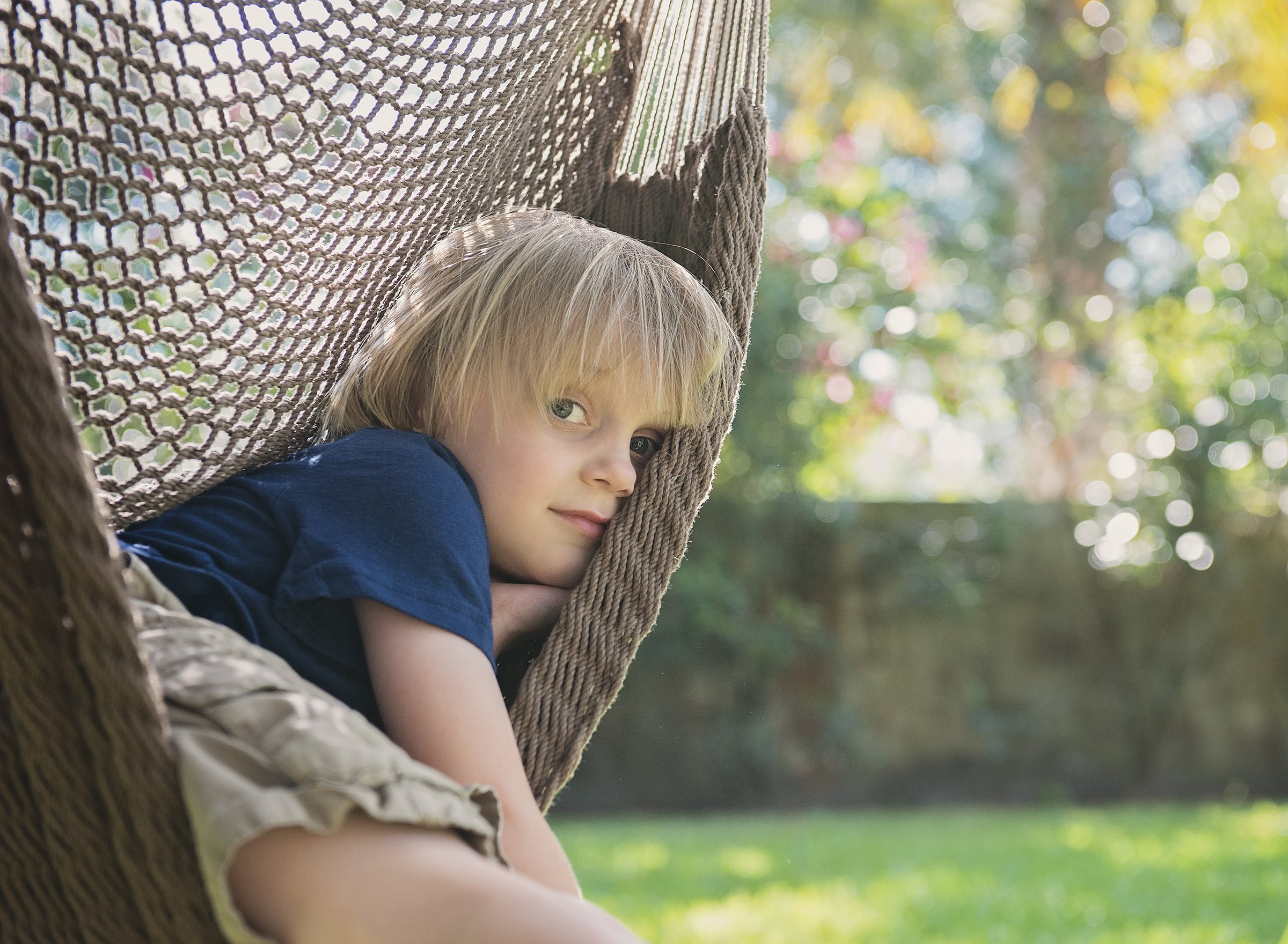 Young boy in hammock in backyard