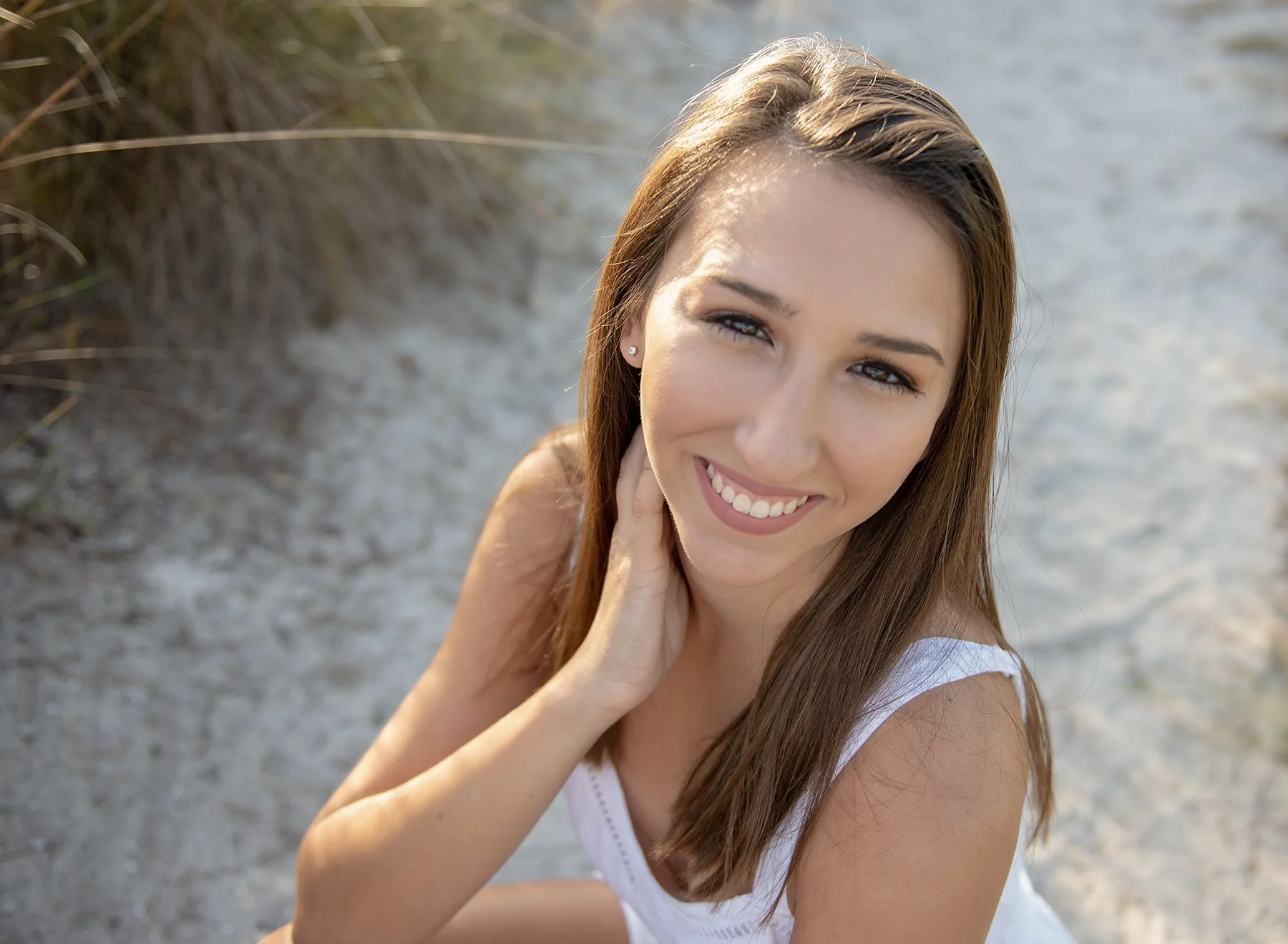 Teen girl kneeling on the beach at Cypress Point Park in Tampa