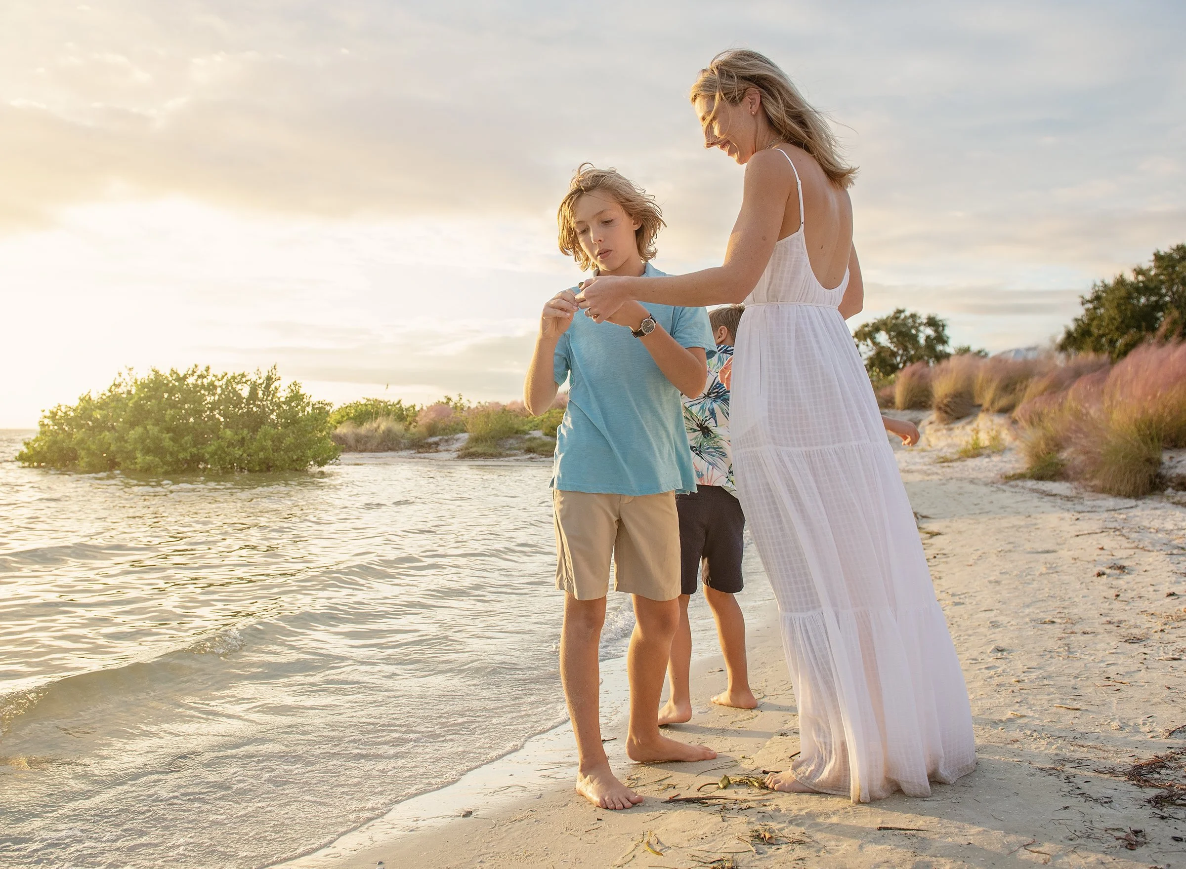 Young boy showing woman a shell on the beach at Cypress Point Park