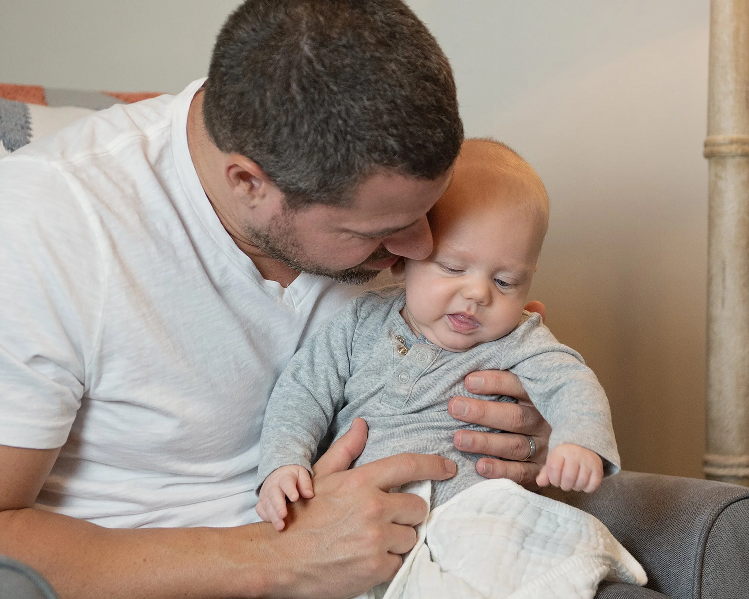 Man holding newborn baby on his lap