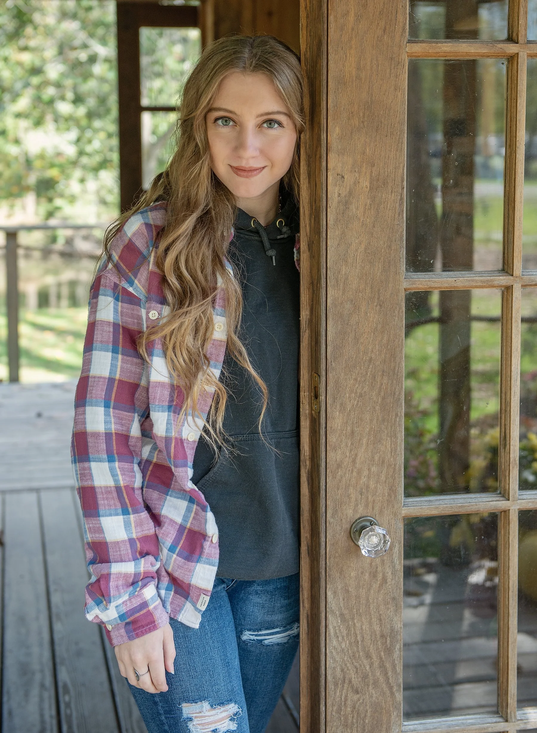 Teen girl standing next to a wooden door