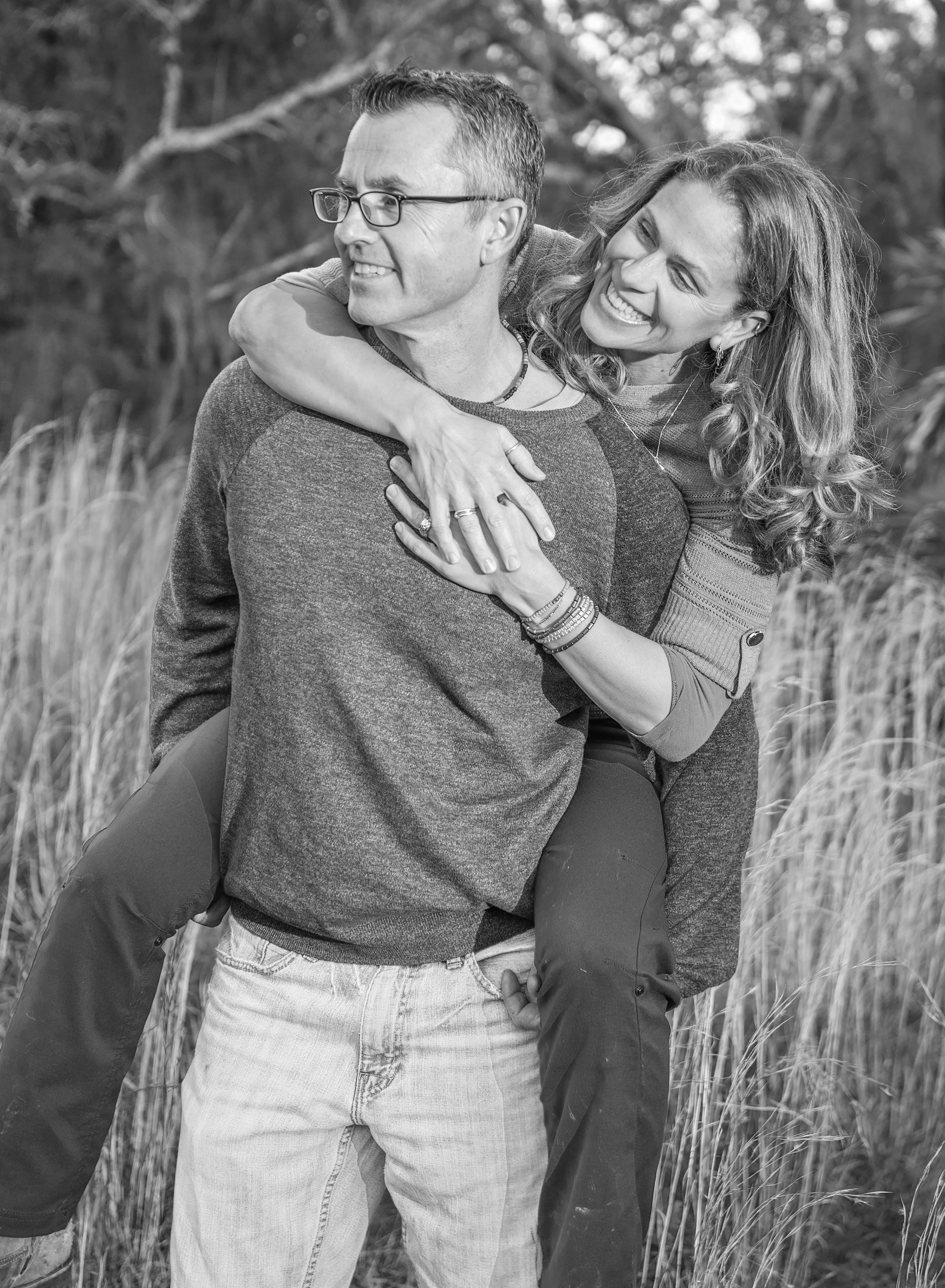 Smiling man with woman on his back in a field in Odessa