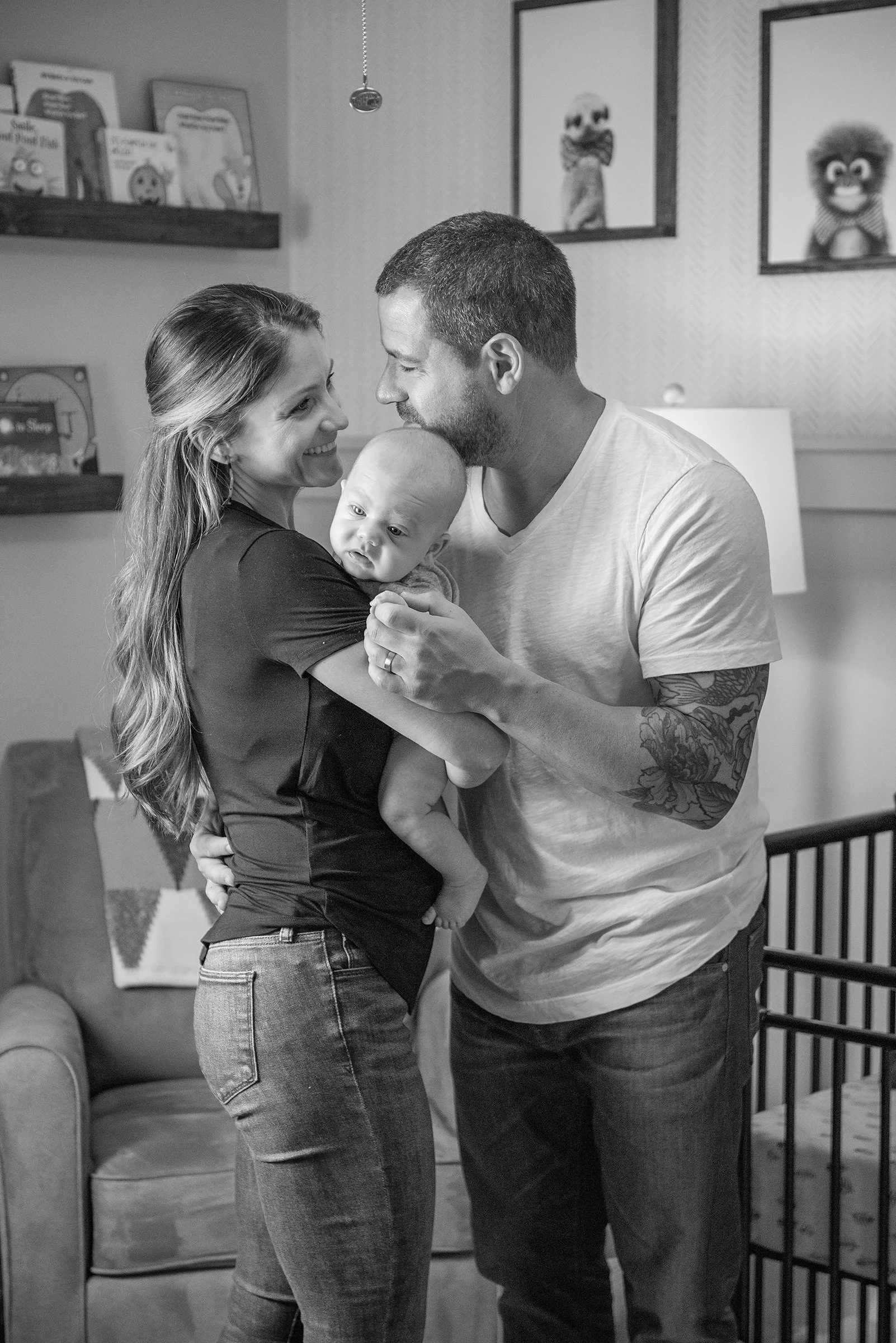Woman and man holding newborn baby between them