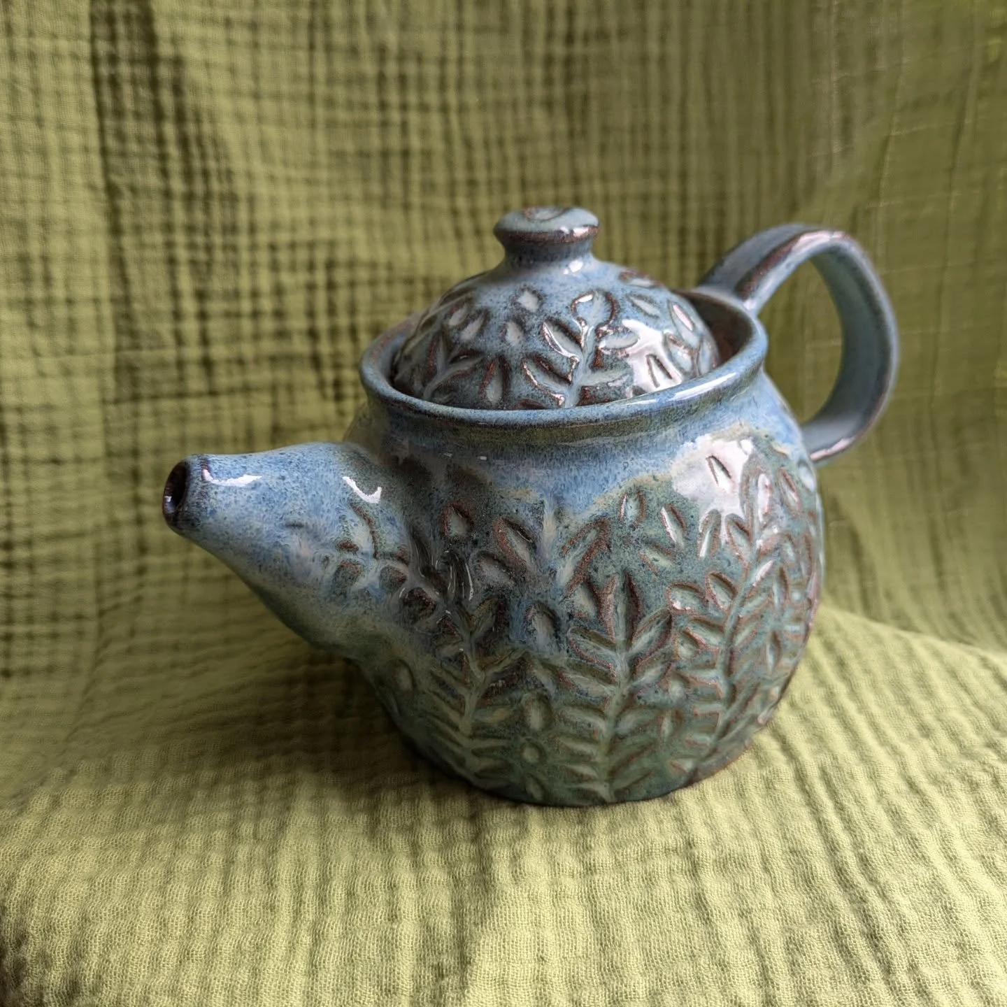 Carved teapot in floating blue