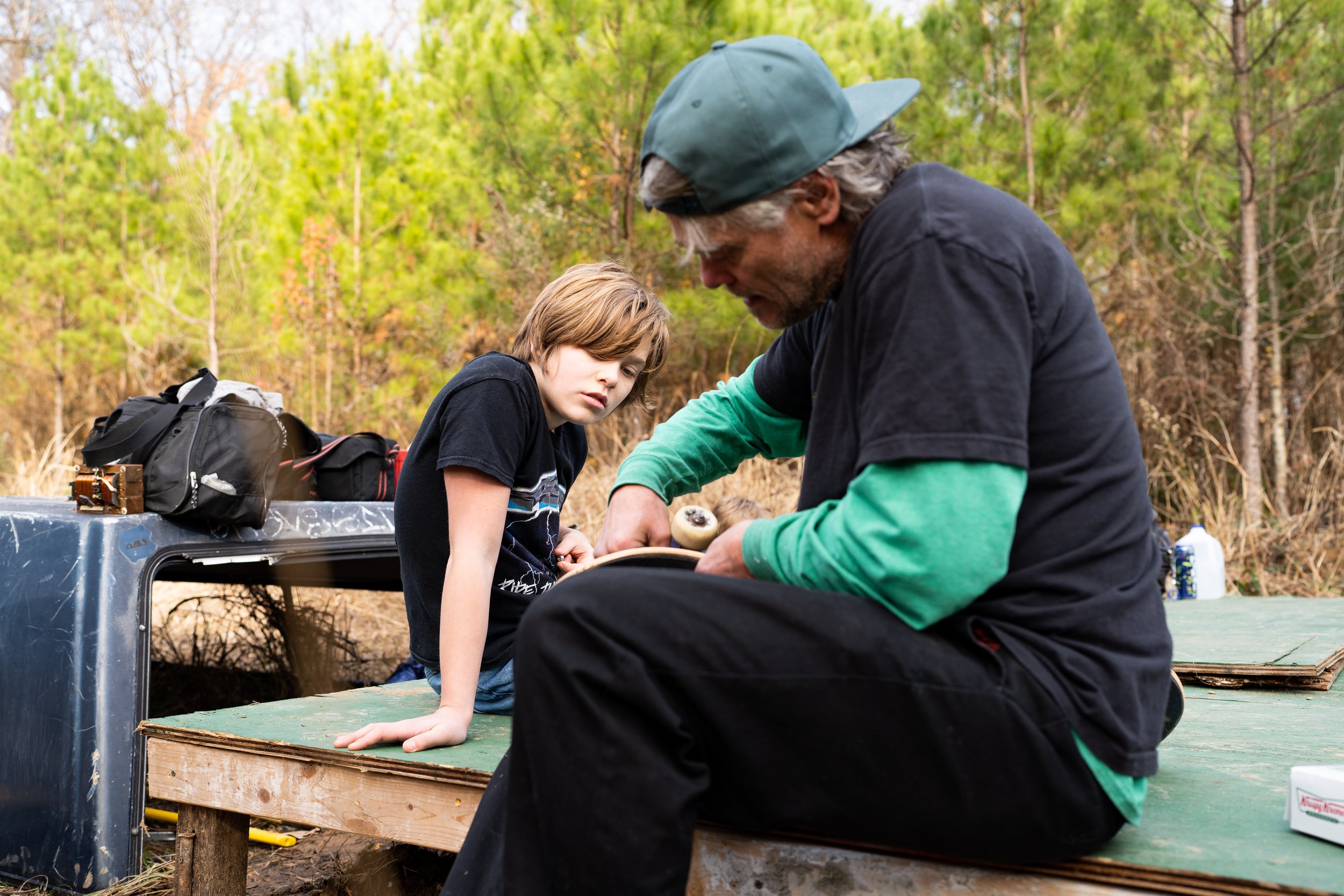 Edwin Jeager's son watches as he assembles a skateboard deck for him at Graveside on December 17, 2024.