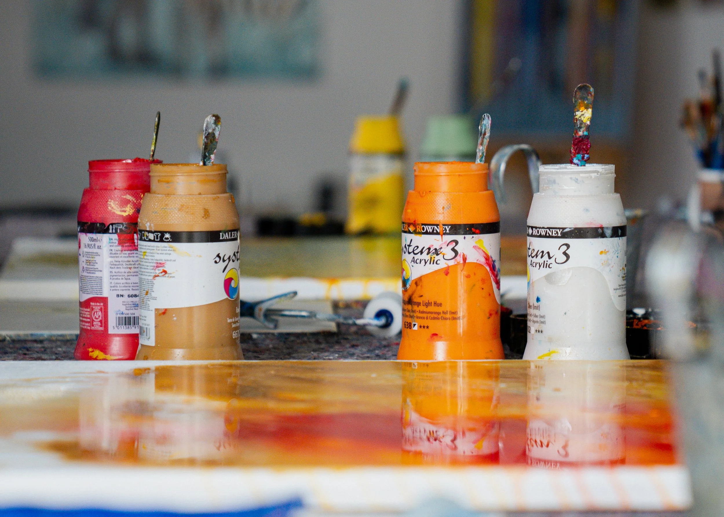 Dosen mit bunten Acrylfarben und Pinsel, Anzeichen von Kunstarbeiten.