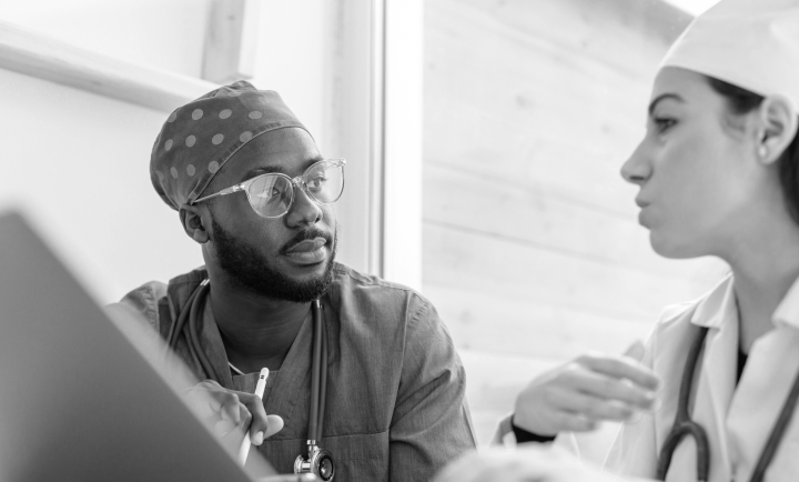 Two healthcare professionals having a serious conversation in a medical setting.