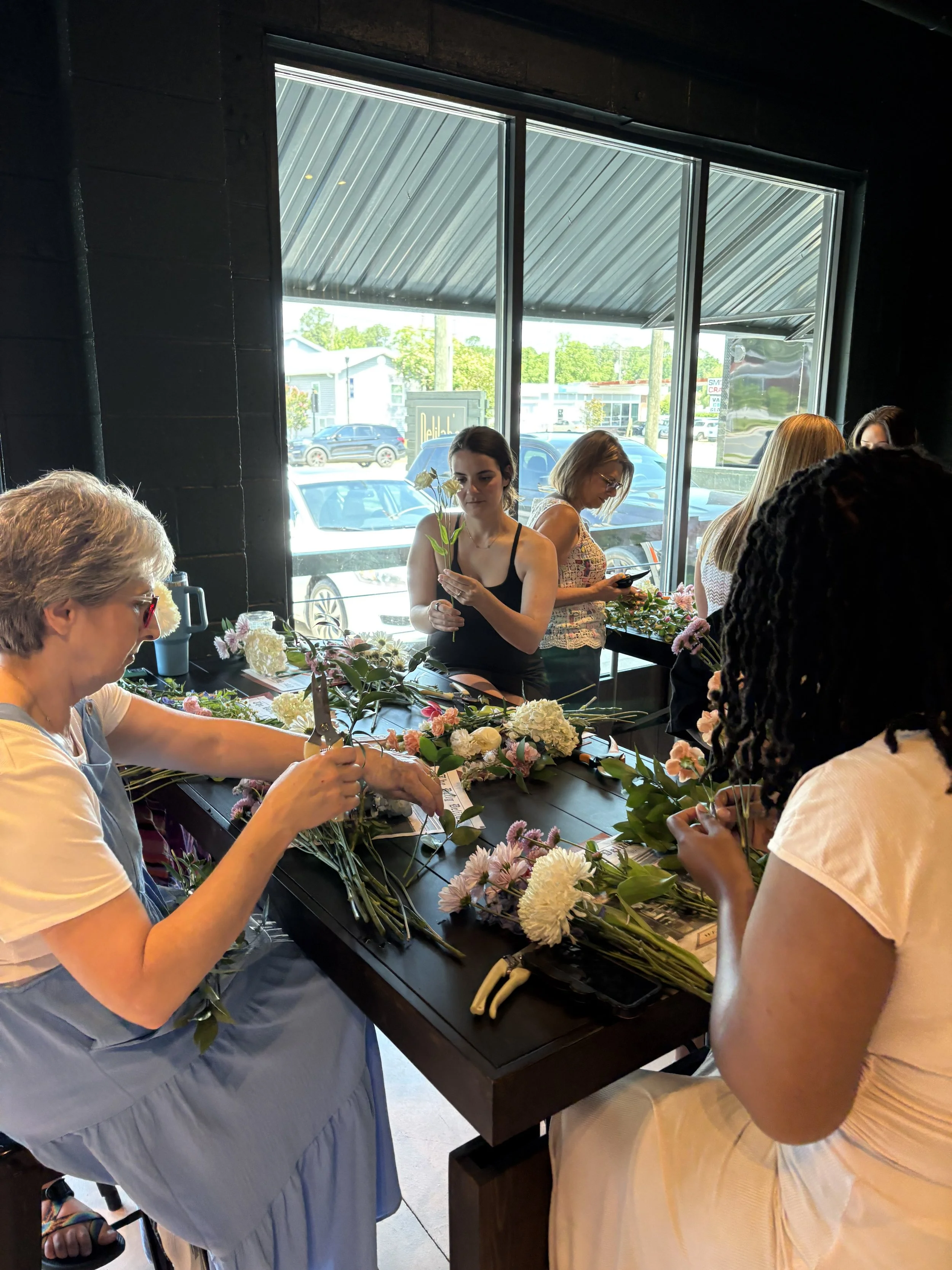 Guests creating hand-tied bouquets during a floral design workshop hosted by Delilah's Flower Shoppe in Statesboro, Georgia.