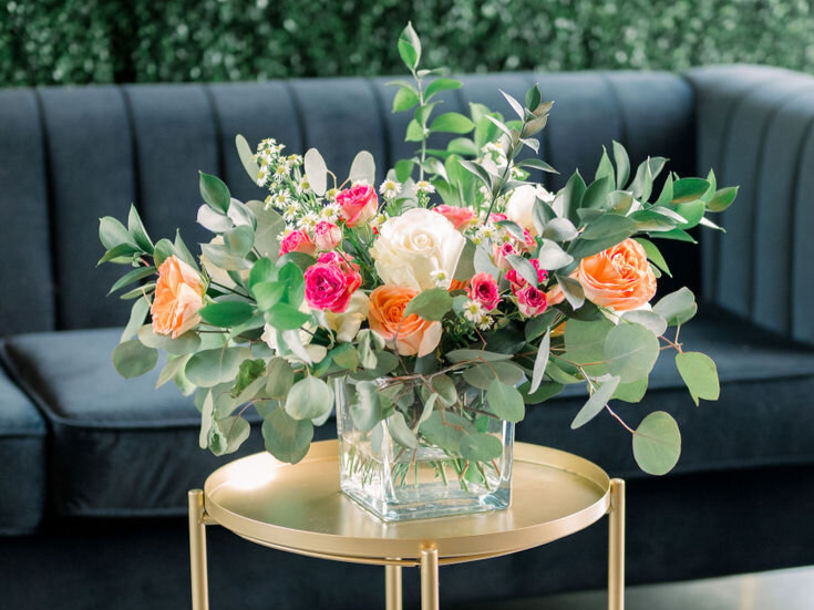 Centerpiece floral arrangement with greenery, roses, mini roses, and daisies by Delilah’s Flower Shoppe in Statesboro & the Coastal Empire.