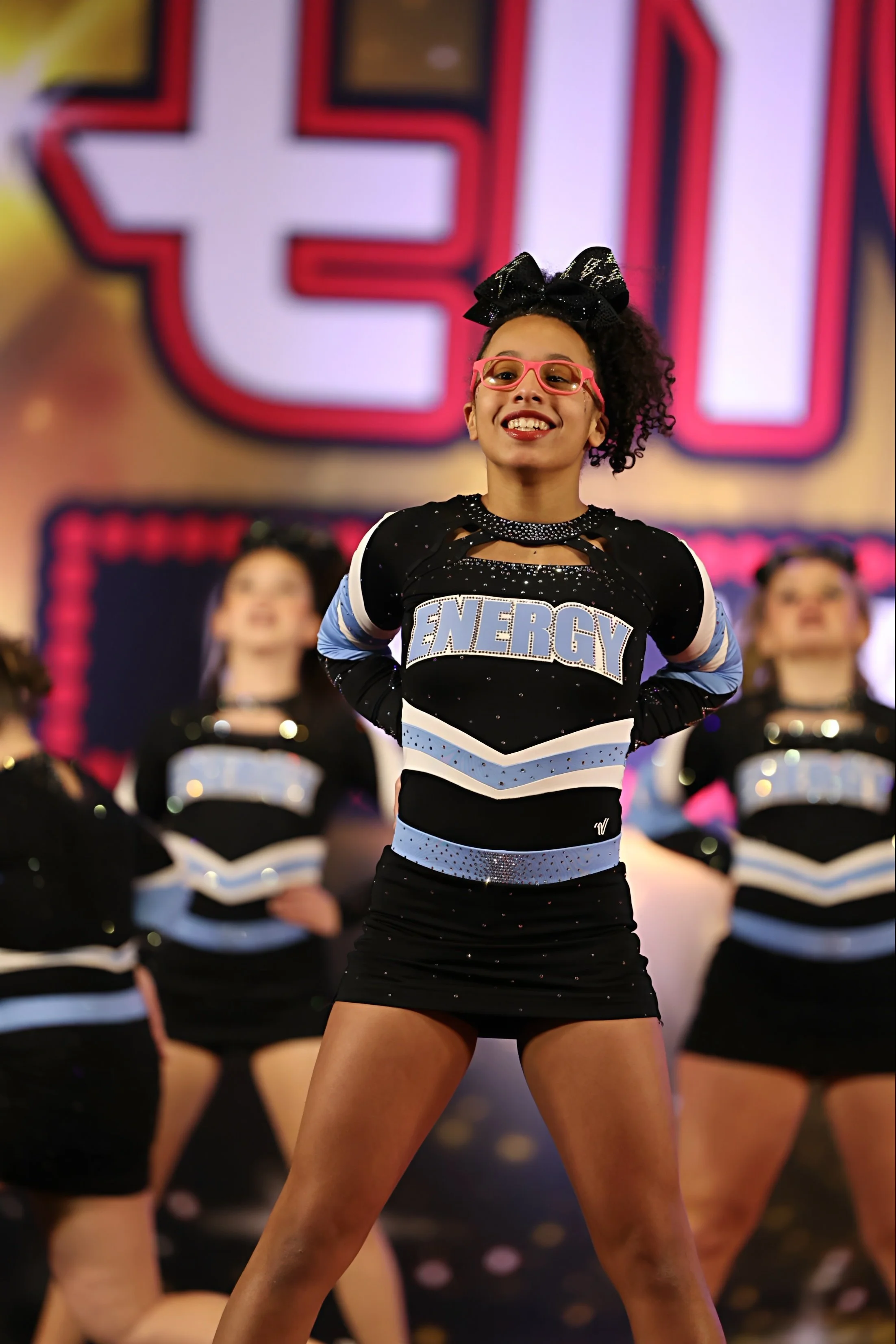 Energy cheerleader in uniform performing at competition