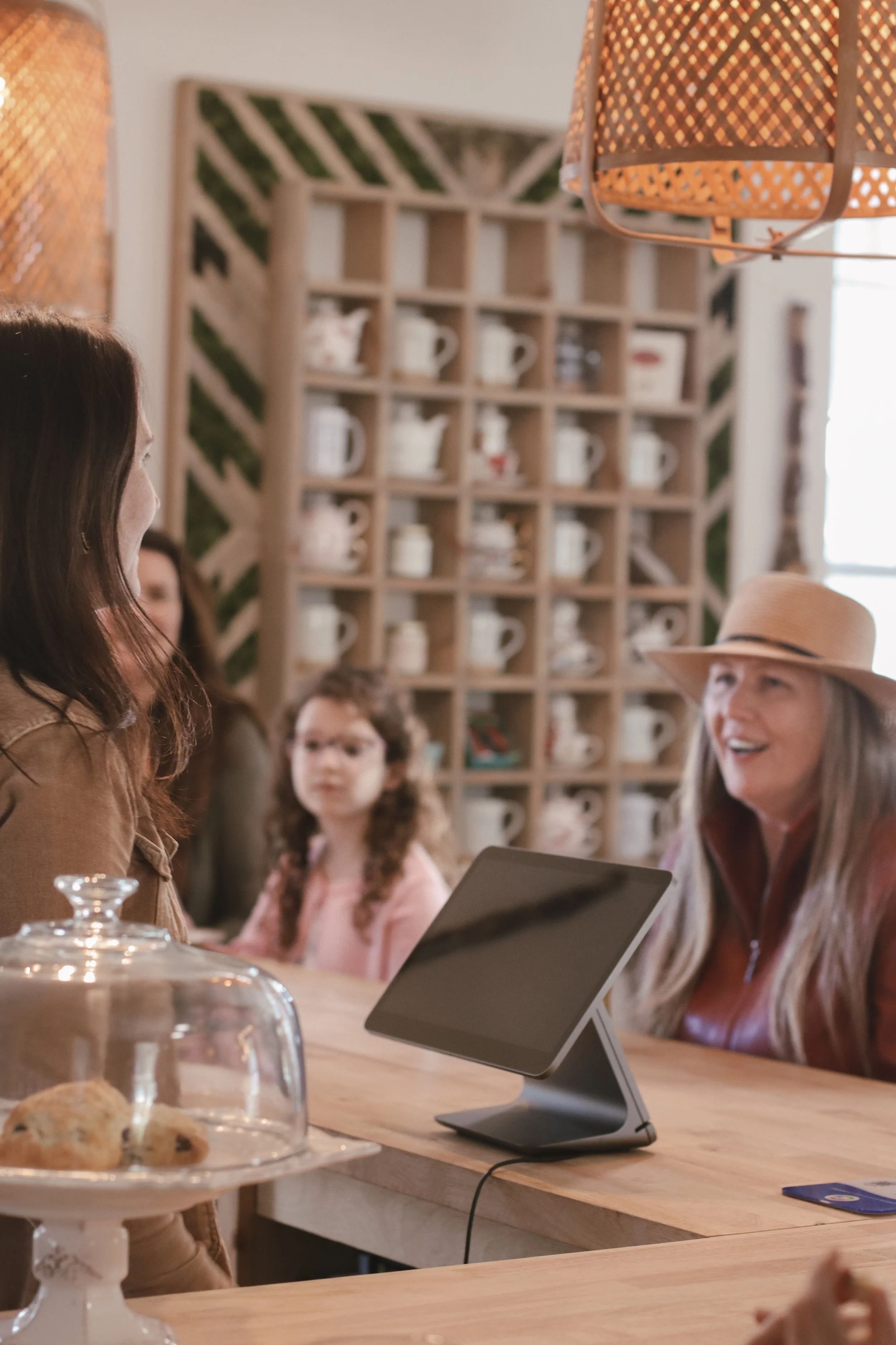 Herbalist greeting smiling customers asking about herbal drinks