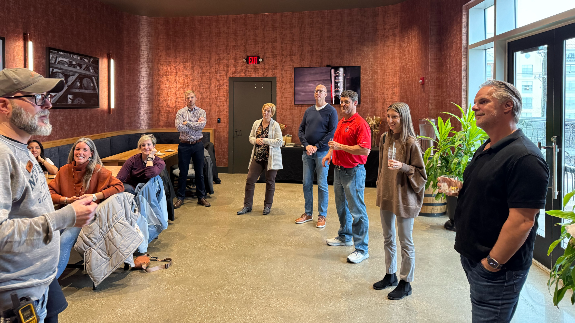 group of people standing in a meeting room holding drinks at new riff distillery