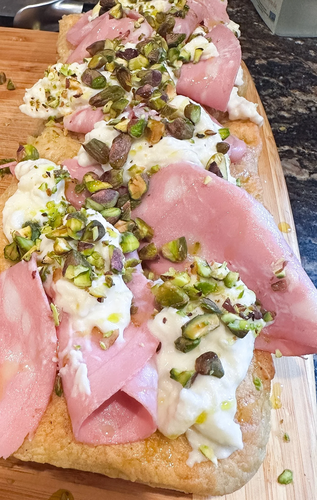 Pinsa with Mortadella, Burrata, and Pistachio served at a Mortar Pestle Cooking event