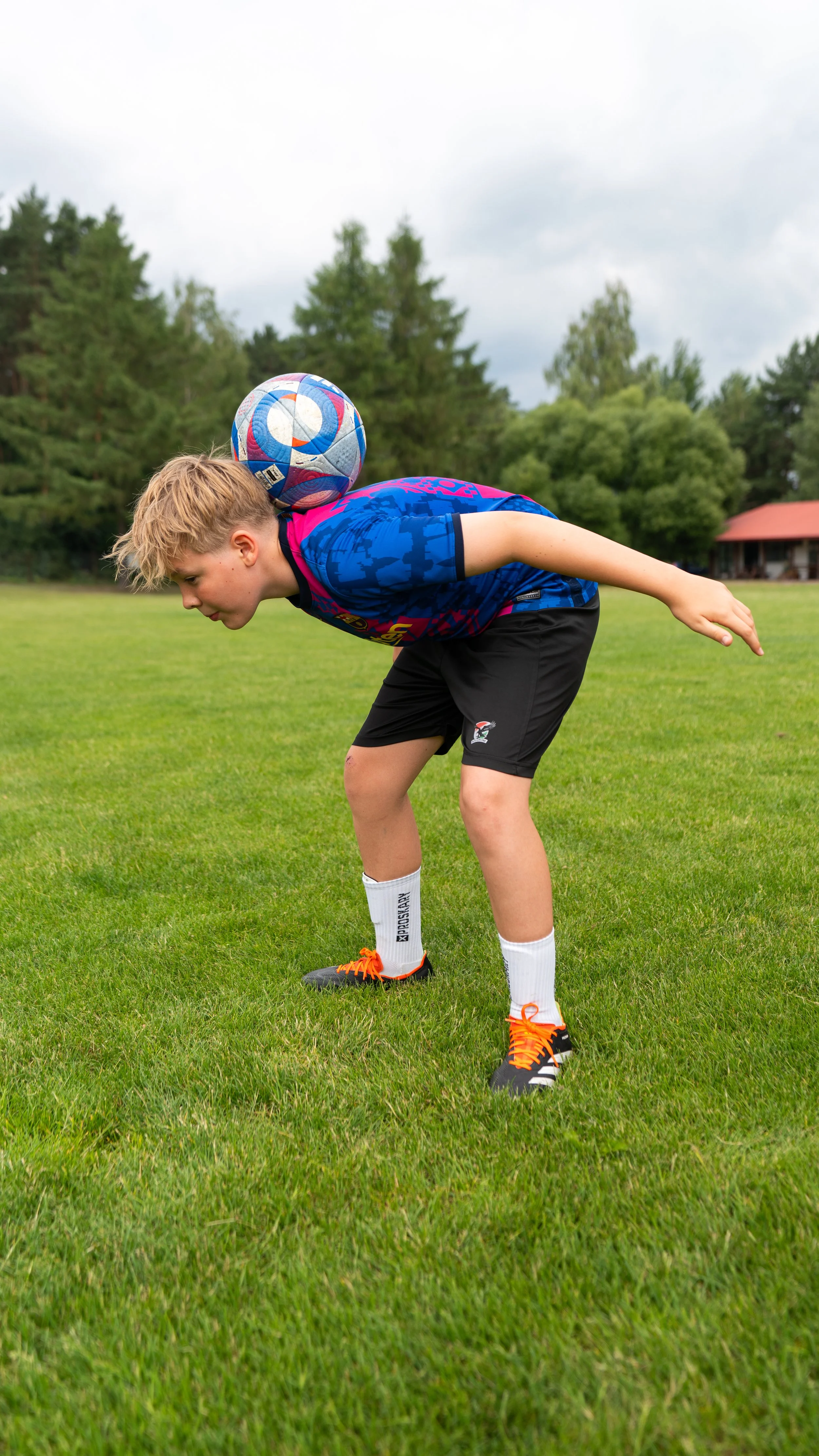 Soccer player balancing ball on forehead on field