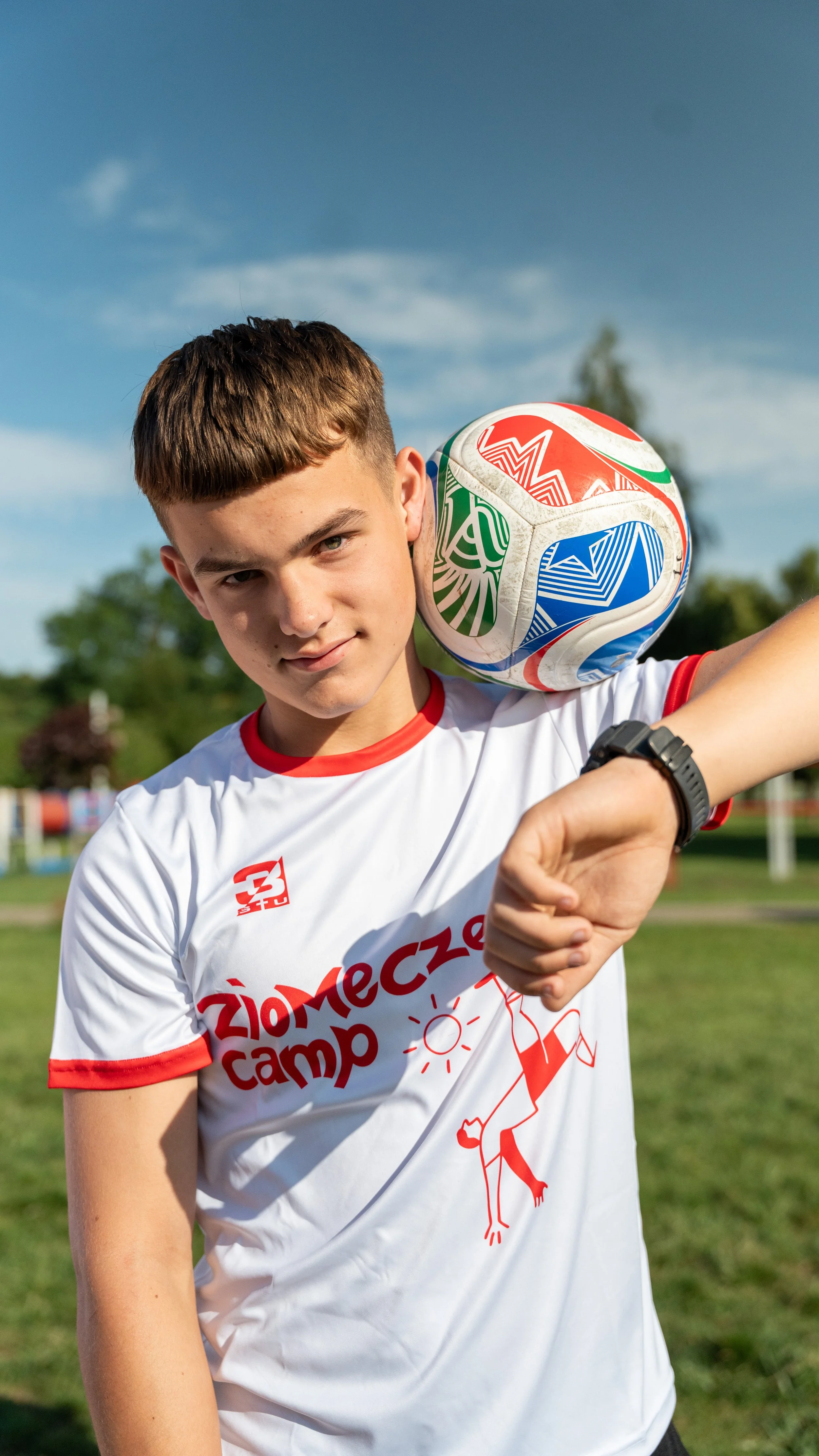 Soccer player balancing ball on forehead on field