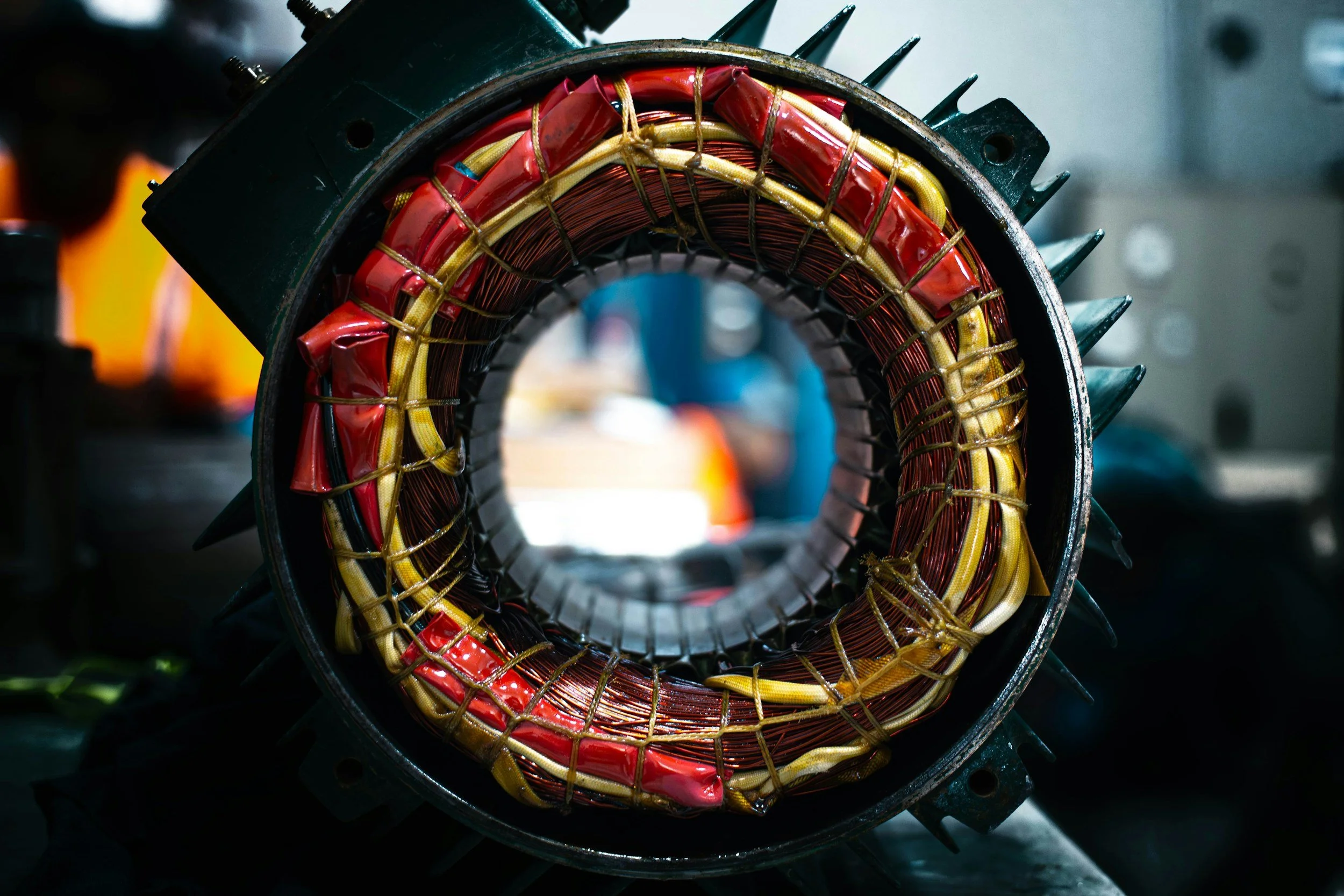 Disassembled electric motor showing the exposed interior with coiled copper wiring and mechanical components visible.