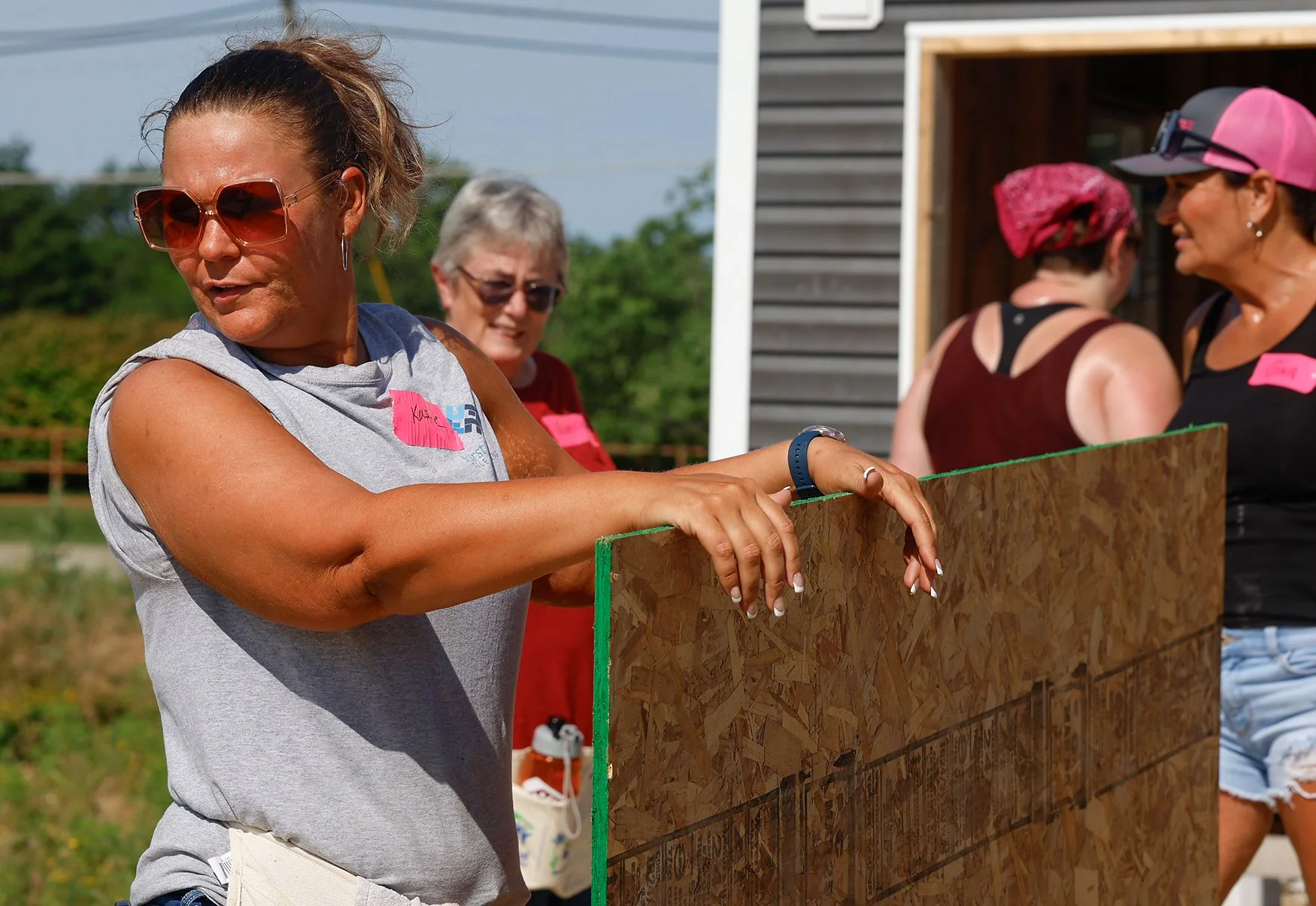 Kassandra Ridgeway, a recipient of a Habitat for Humanity home, holds a board during the Pride Build event on Saturday in north Columbia. Ridgeway applied for a home in February and was fully approved by April.