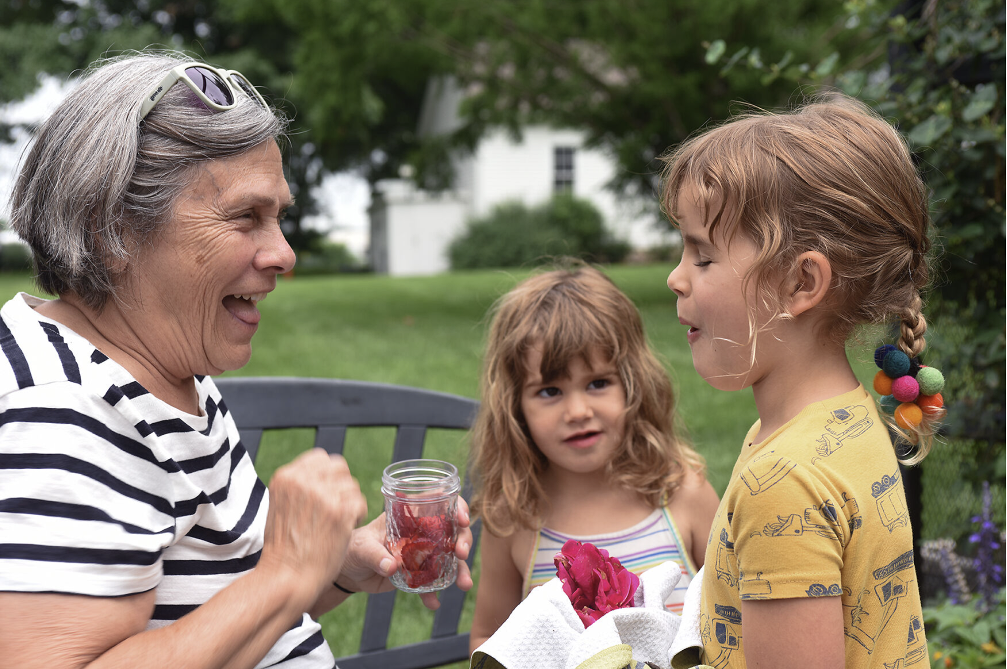 Nancy Kassabaum, left, feeds a strawberry to her granddaughter Orella Kassabaum, 6, as Orella’s sister Savi, 3, watches Thursday at Shelter Gardens. Shelter Insurance marked the 50th anniversary of its gardens, which are open to the public, with a sp