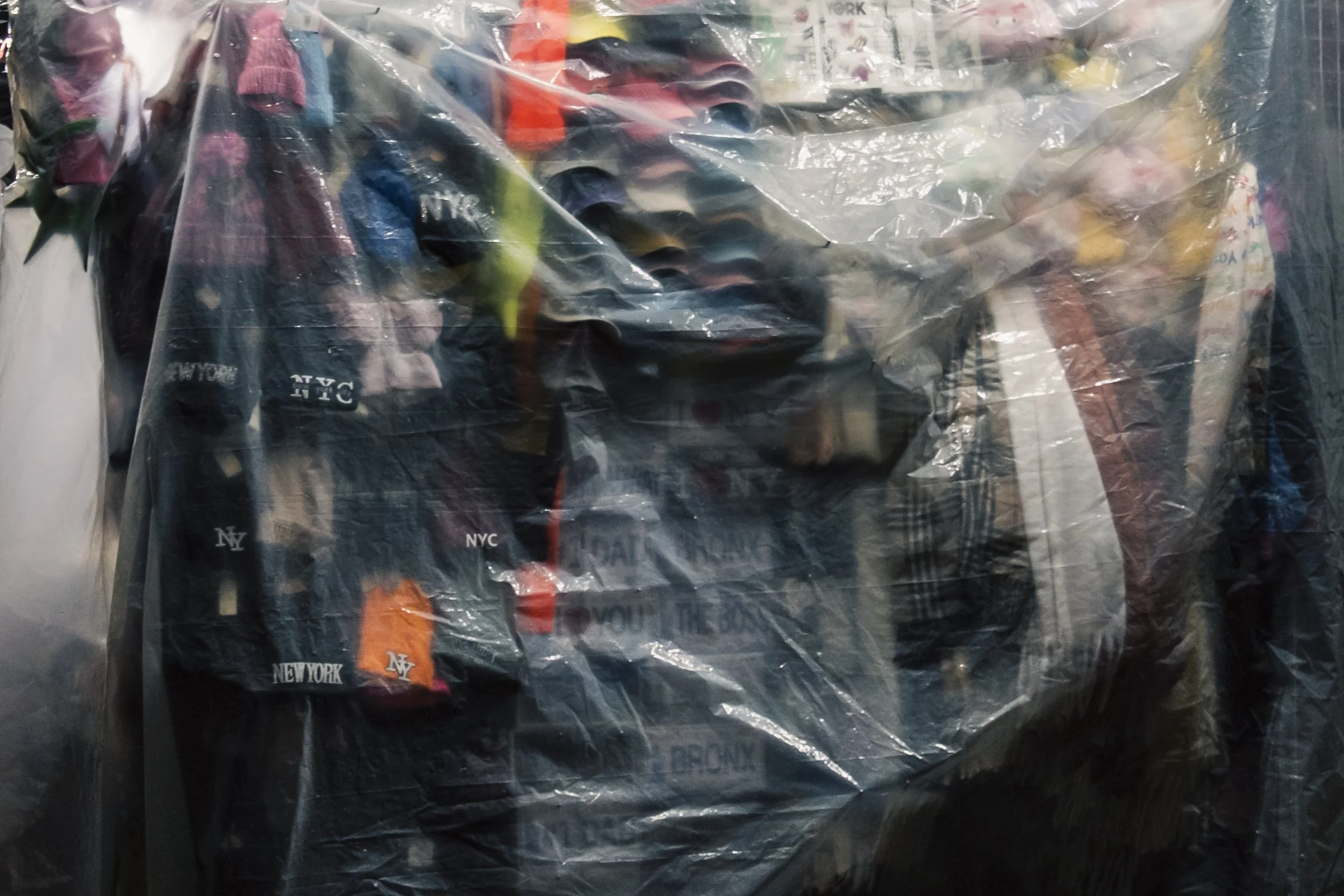 A pile of colorful socks inside a clear plastic bag, with some socks featuring city names like New York and NYC.