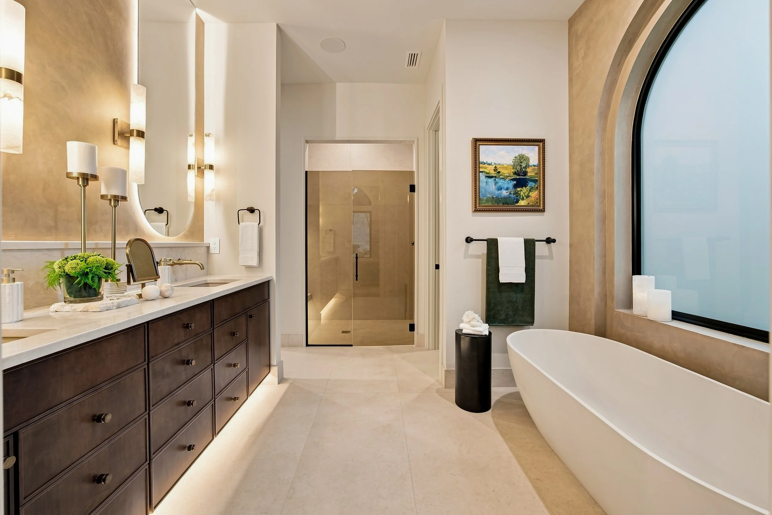 Bathroom with a dark wood vanity, freestanding tub, and sculpted arched window at Sculpted Elegance.