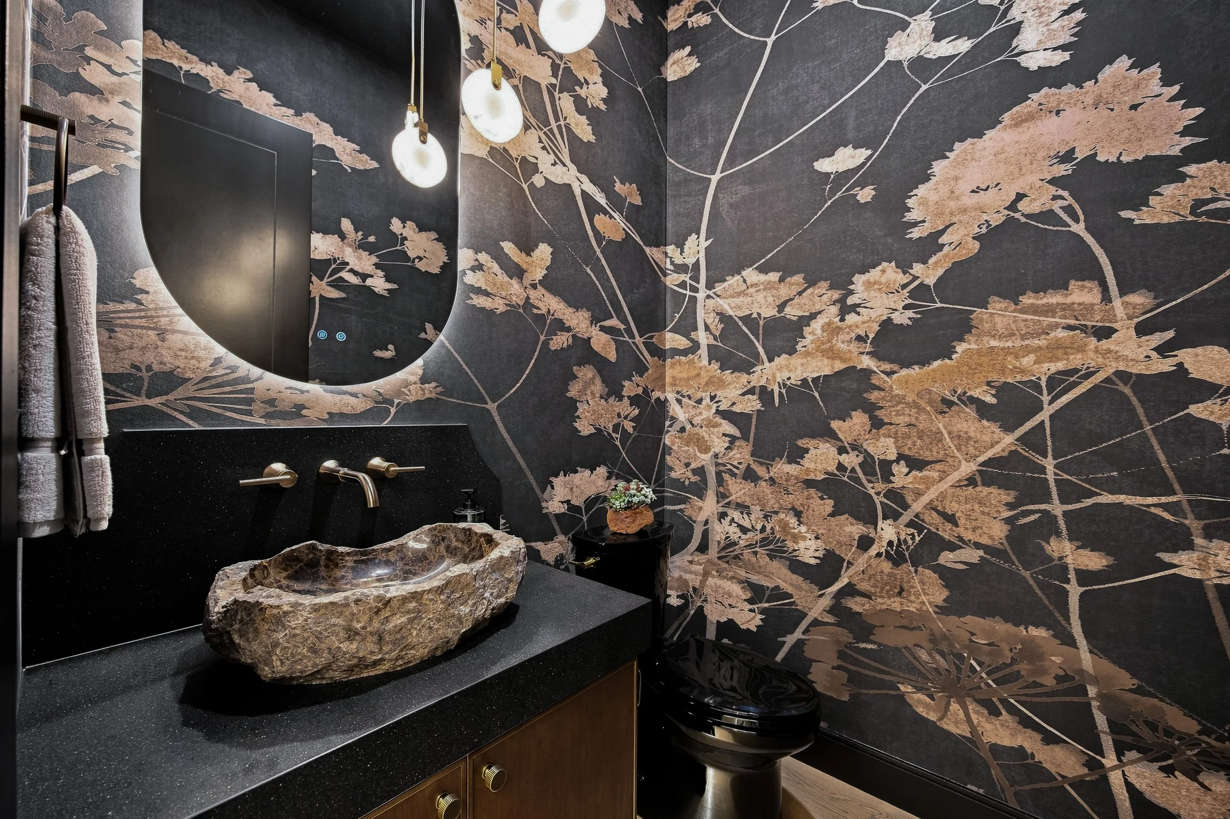 Powder room with a dark botanical wall covering and vessel sink.