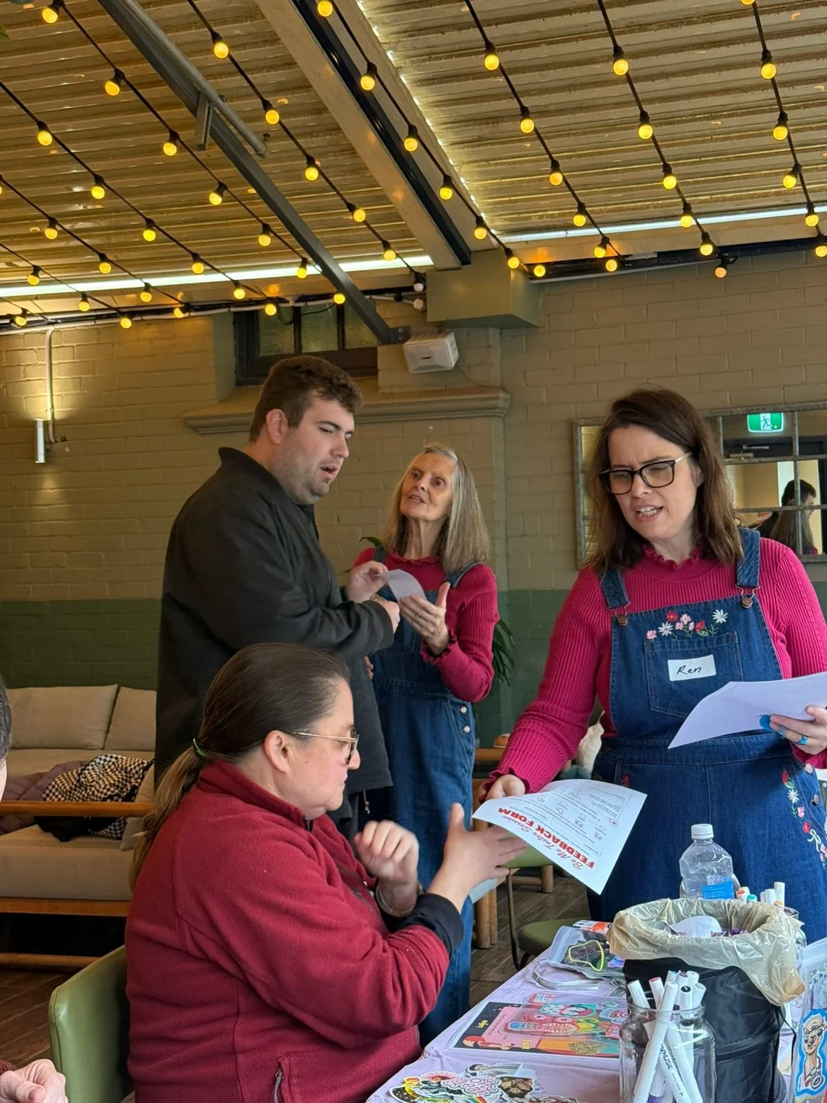 People sitting and standing whilst discussing craft based activity