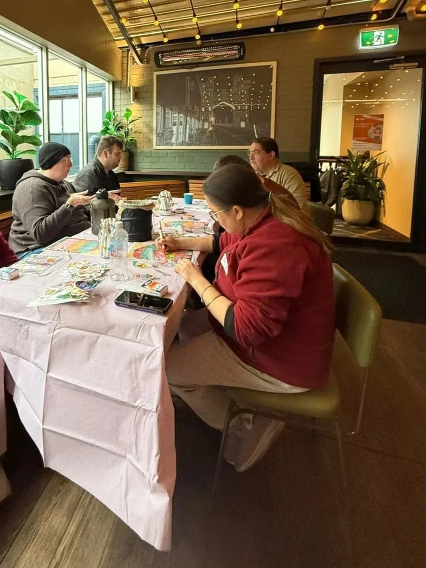 People sitting down creating crafts together