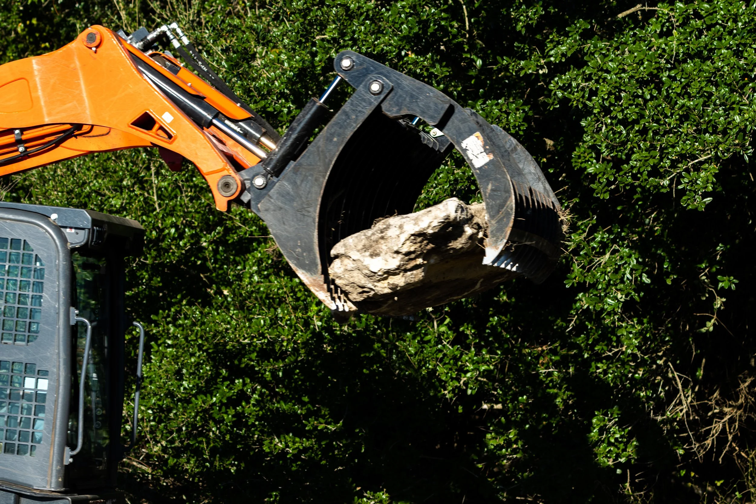 Excavator claw holding a large rock