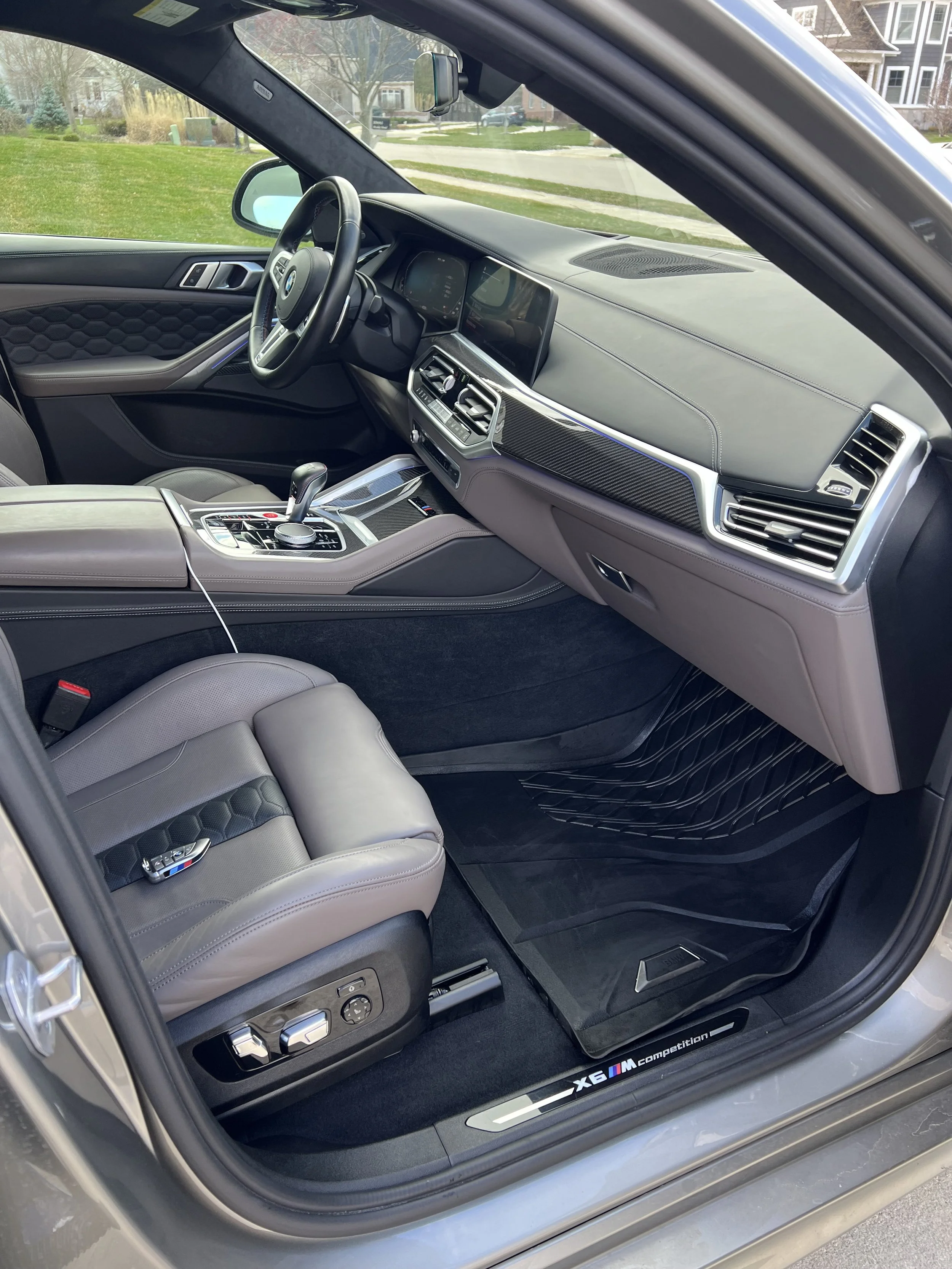 Interior of a luxury car showing the driver's seat, dashboard with modern controls, steering wheel, and center console.