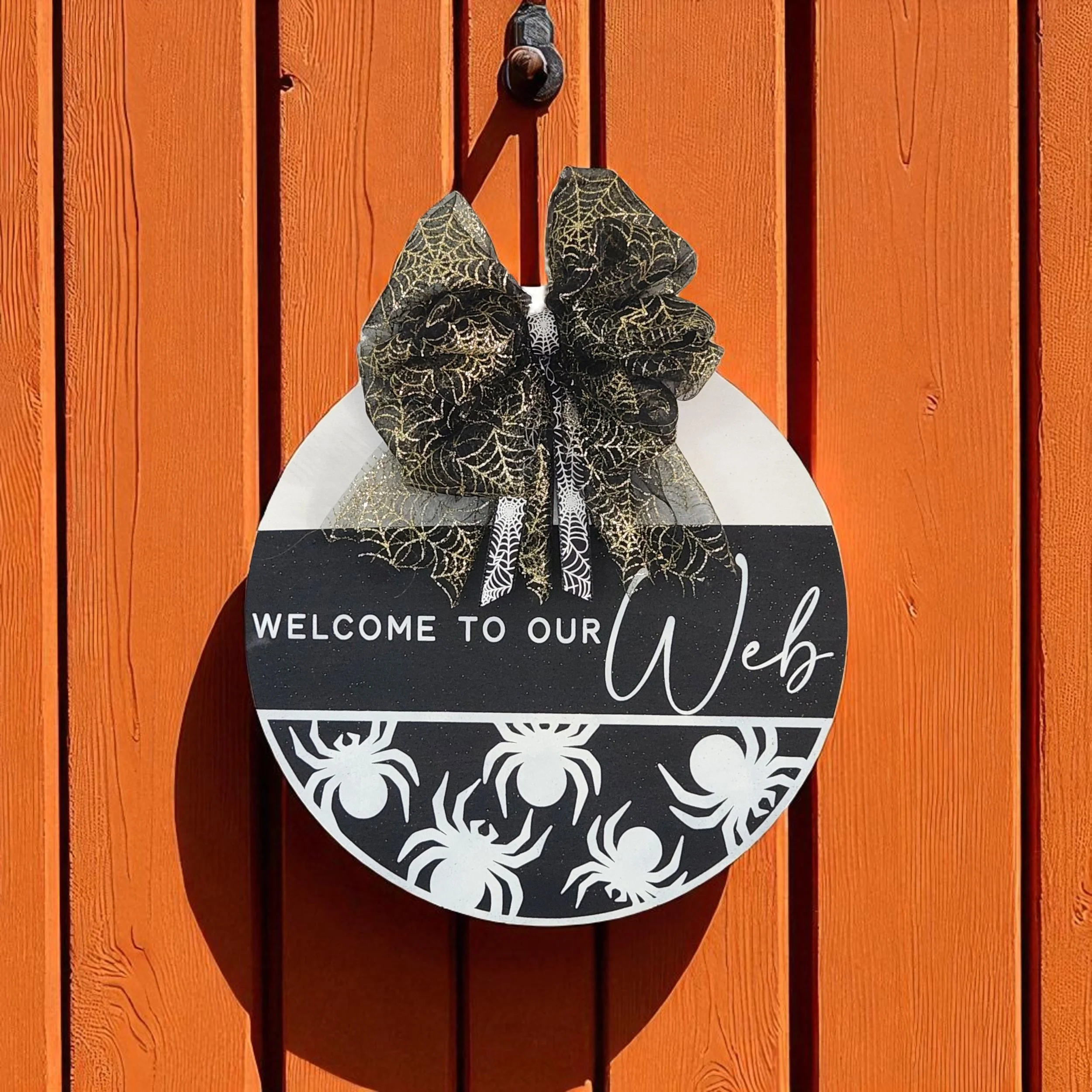 Welcome to our Web Sign hanging on rustic orange wall.