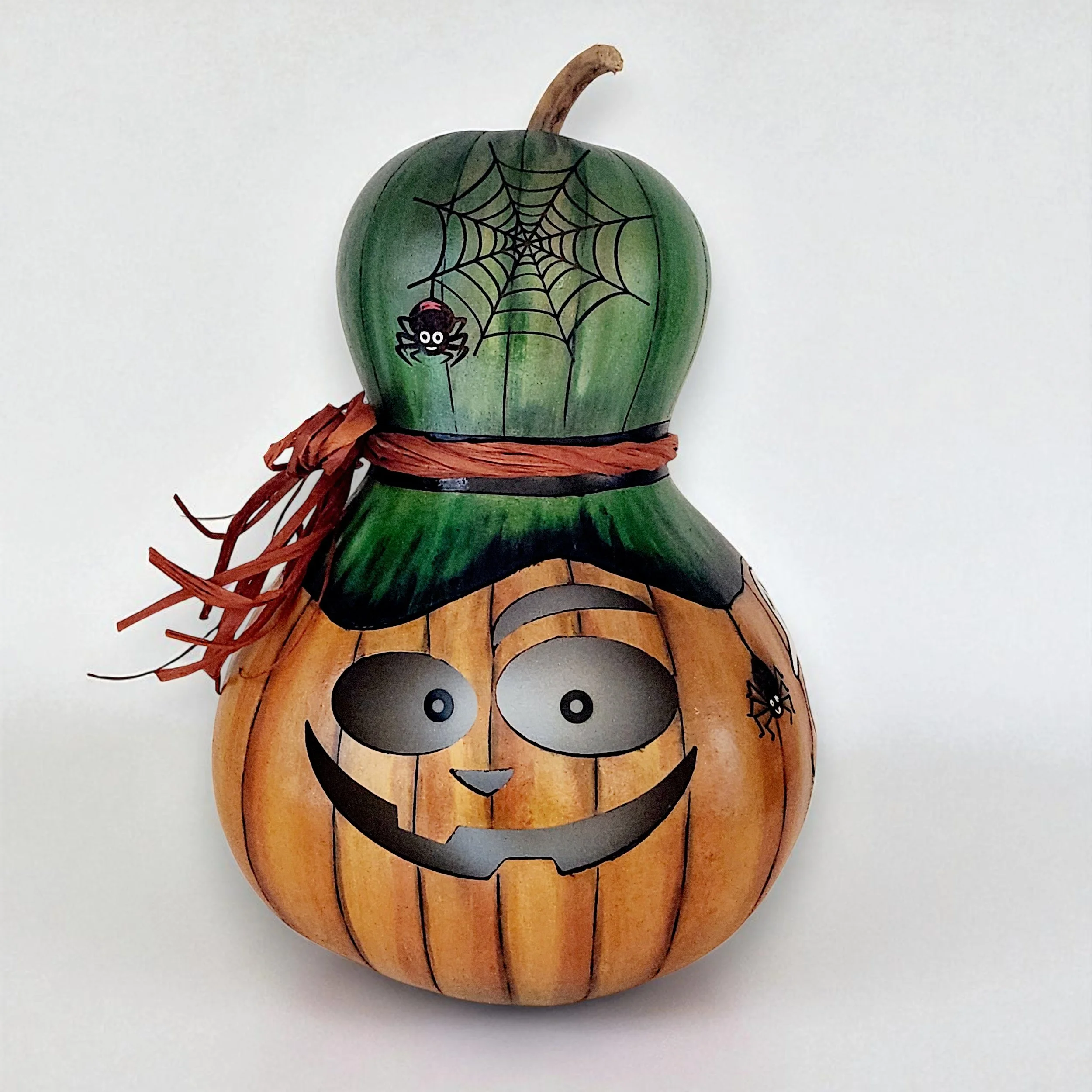 Unlit front view of a handcrafted bottle gourd lantern showing a mischievous jack-o-lantern face.