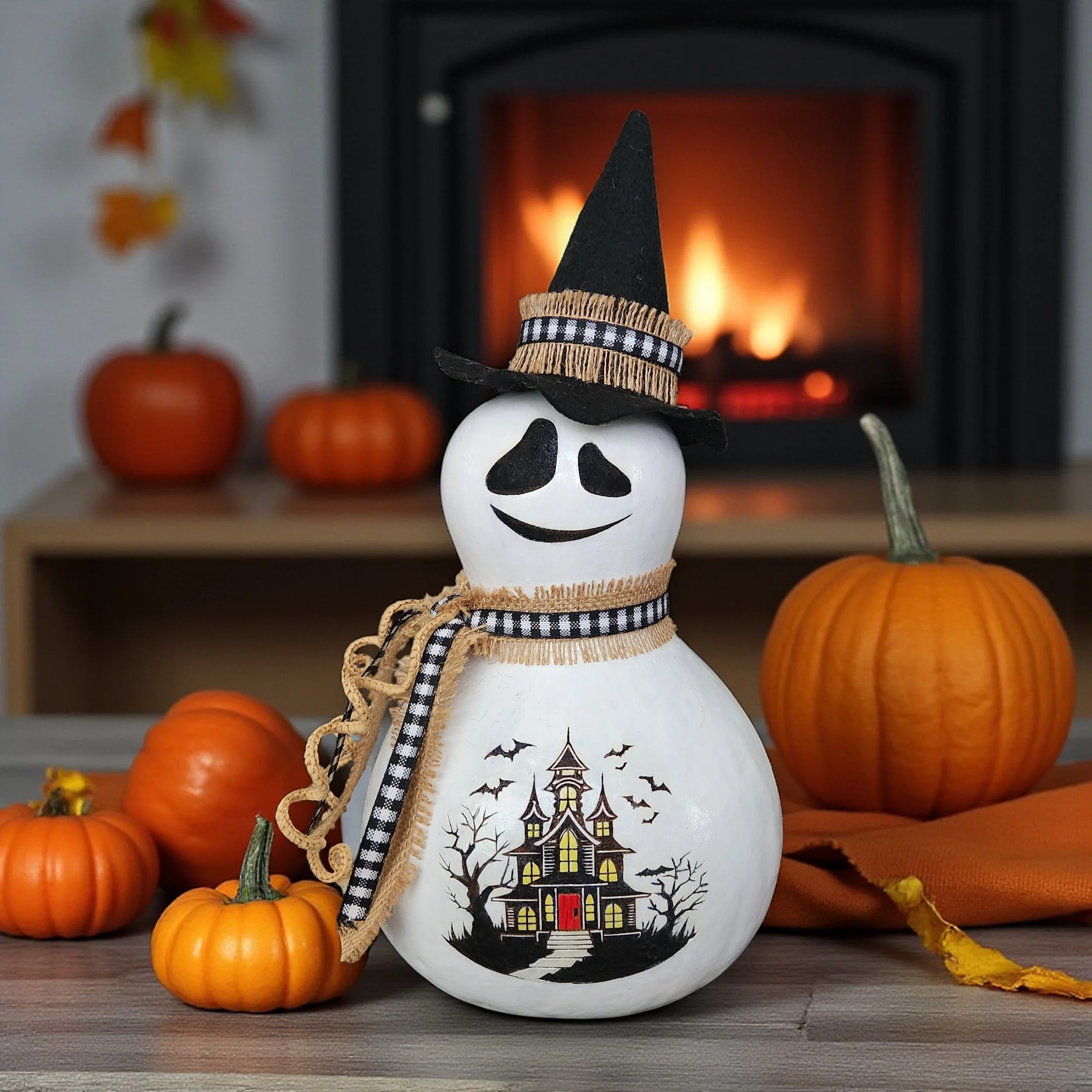 Front view of ghost witch bottle gourd in front of a fireplace.