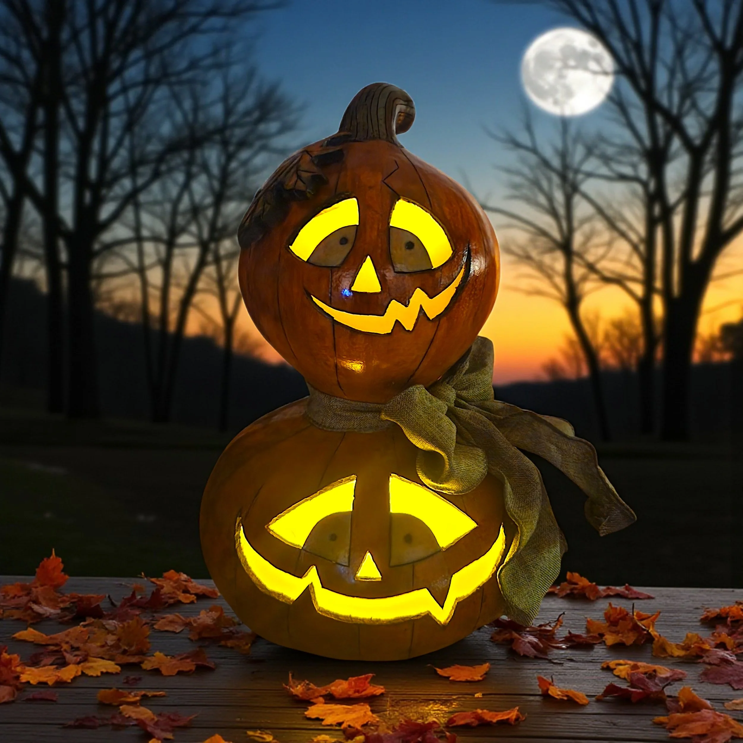 Halloween jack-o-lantern display illuminated from within, showcasing warm yellow glow and festive carved expressions.