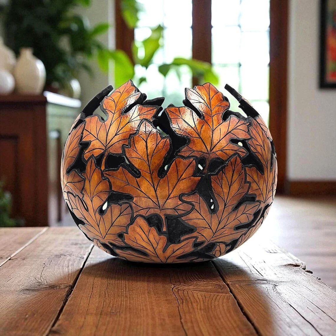 Hand-carved round gourd bowl featuring wood-burned maple leaf design across its surface, stained in earthy brown and yellow ink dyes.