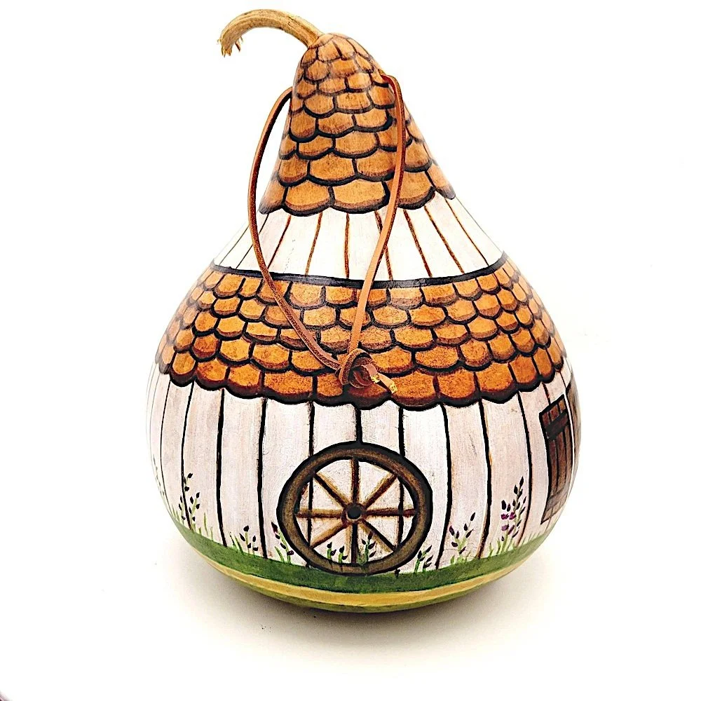 Rear view of the White Barn Gourd Birdhouse, featuring drainage holes and a sturdy leather hanging cord.