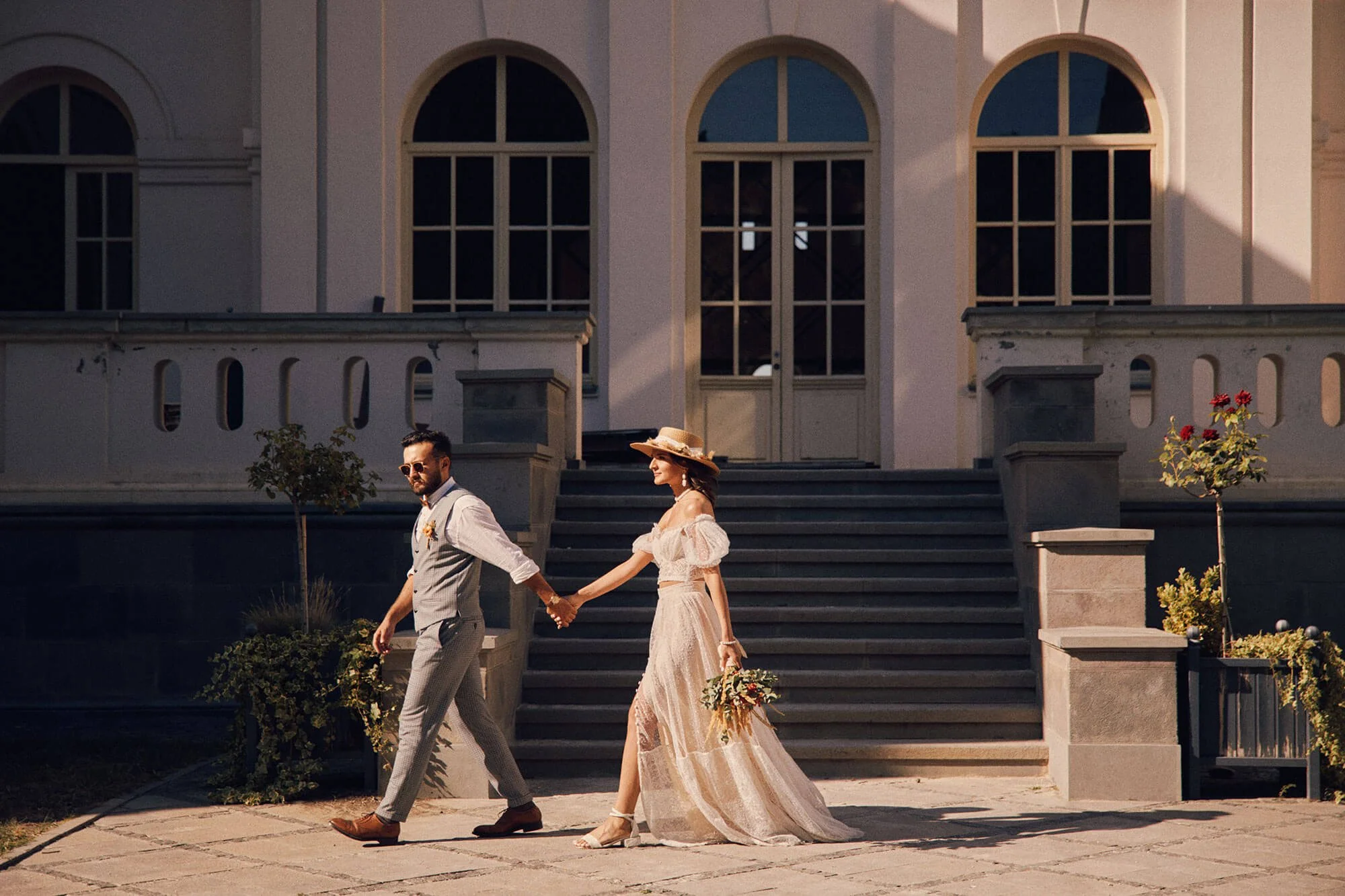 Bride and groom walking down stairs outside a grand building