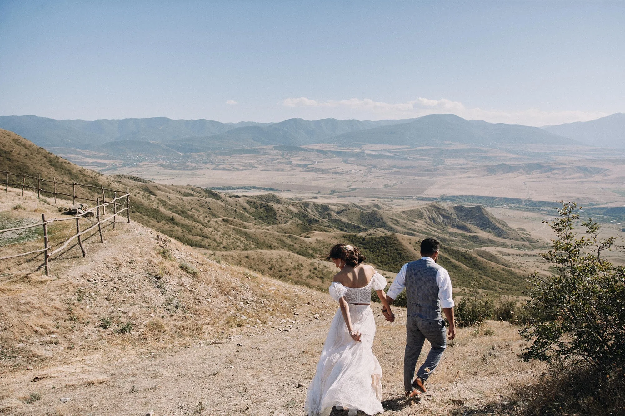Bride and groom walking together in a beautiful mountain landscape