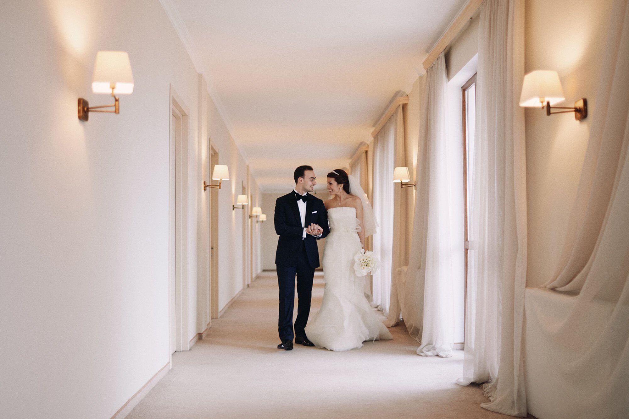Candid moment of engaged couple laughing in hotel hallway