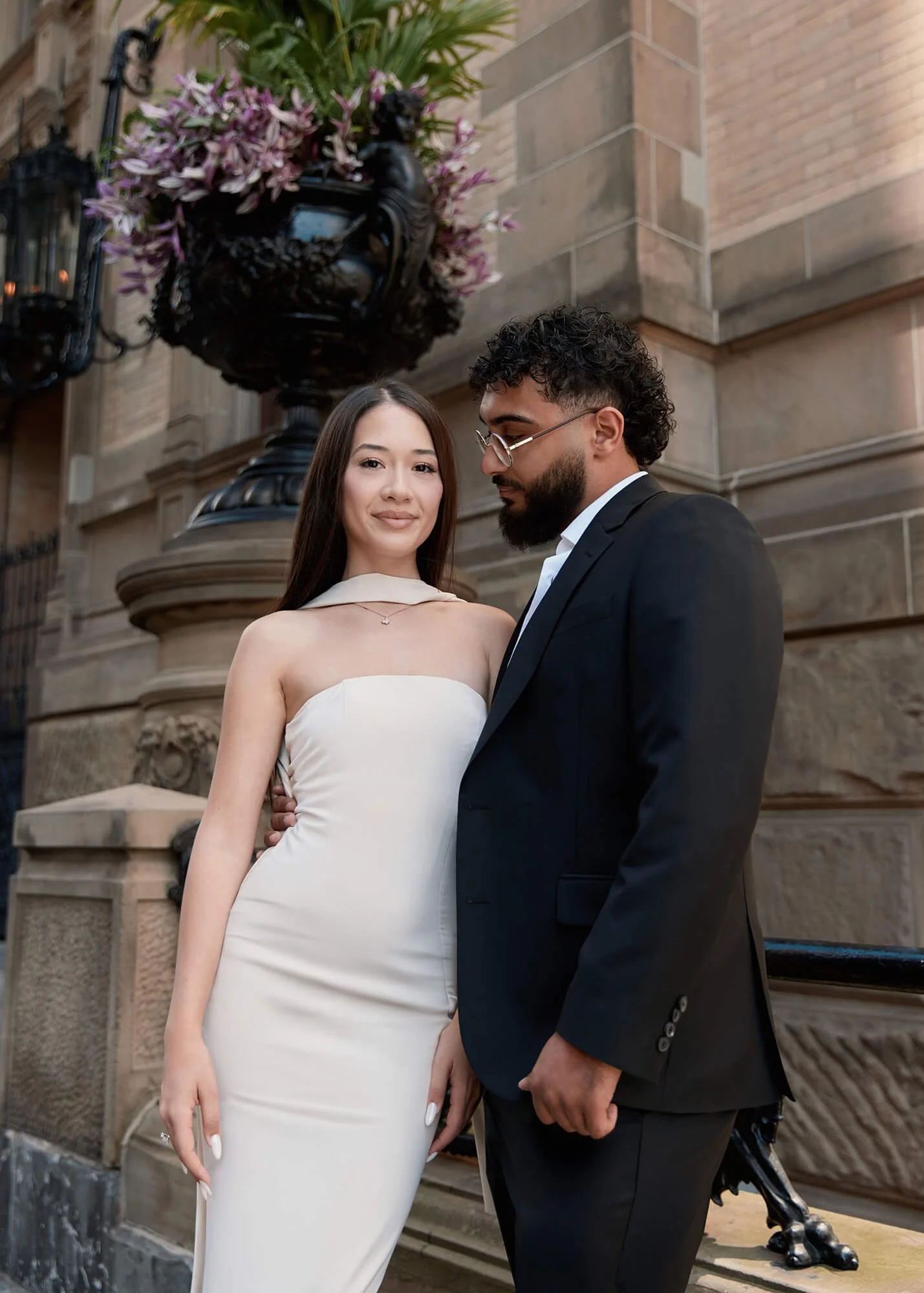 Engaged couple smiling at each other on NYC Library stairs
