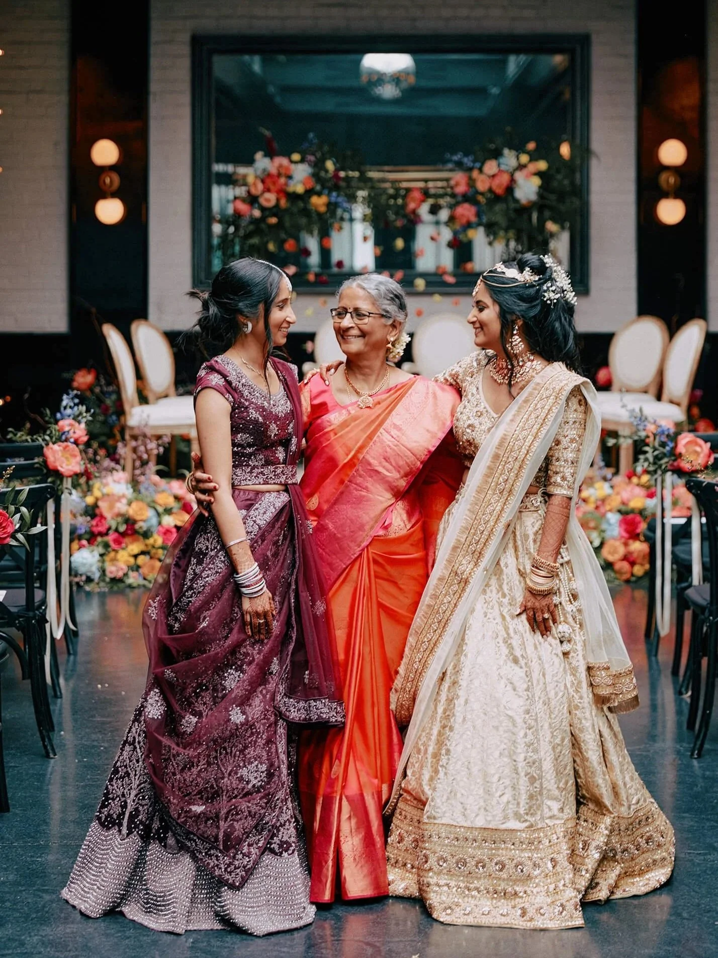 The bride with her mother and sister in vibrant, colorful saris.