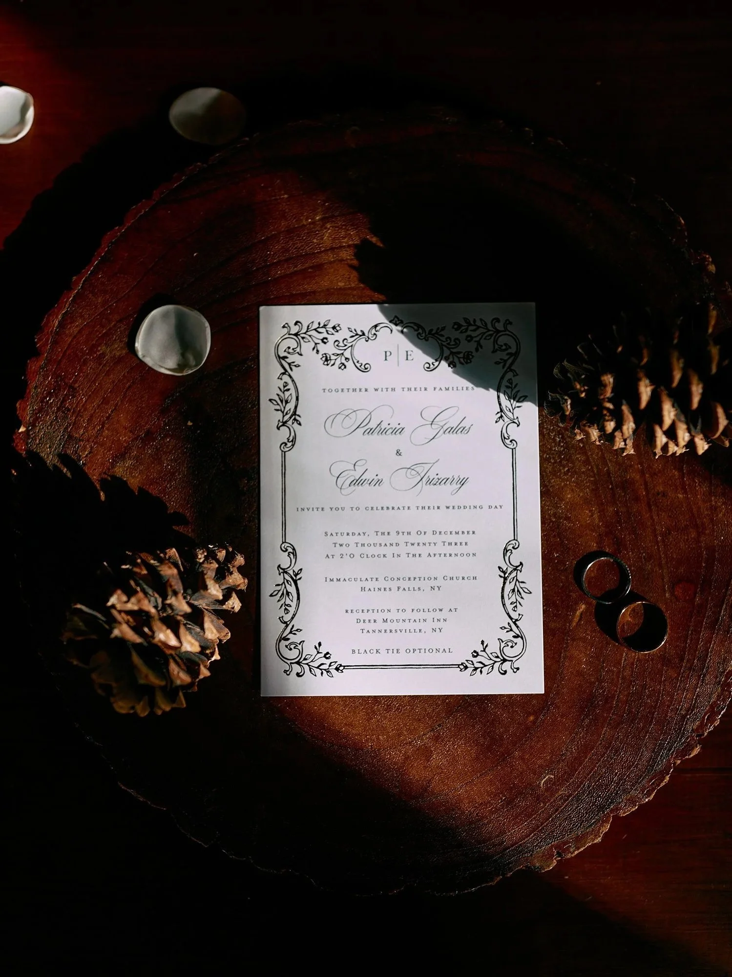 Flatlay of wedding invitation with natural tones and rings